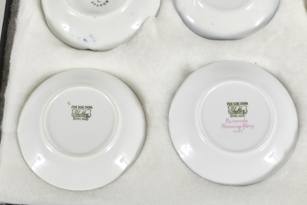 Twelve Porcelain Butter Pats In Glass Top Display Case