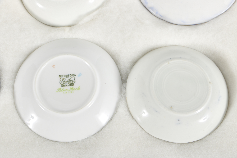 Twelve Porcelain Butter Pats In Glass Top Display Case