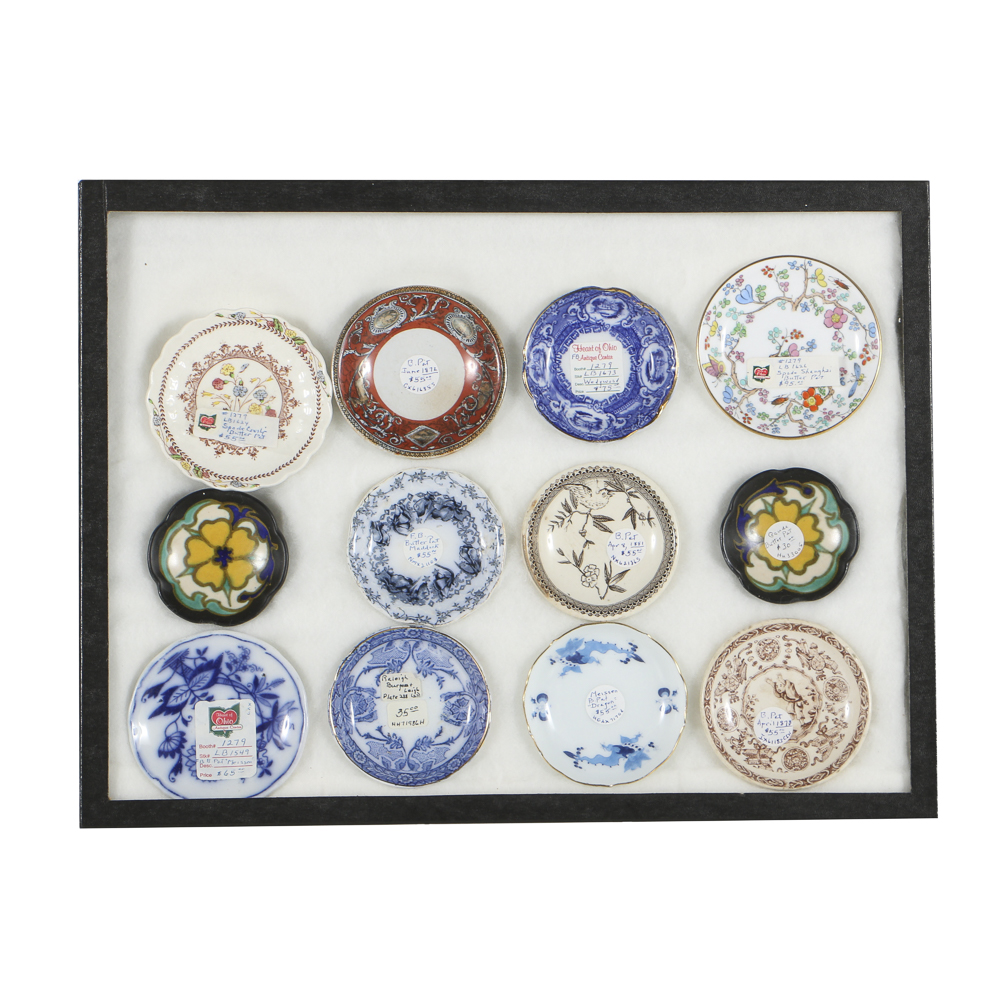 Twelve Porcelain Butter Pats In Glass Top Display Case