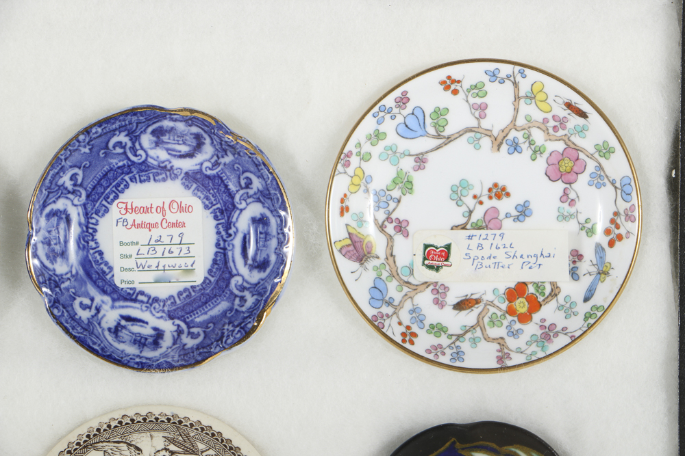 Twelve Porcelain Butter Pats In Glass Top Display Case