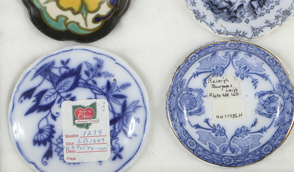 Twelve Porcelain Butter Pats In Glass Top Display Case