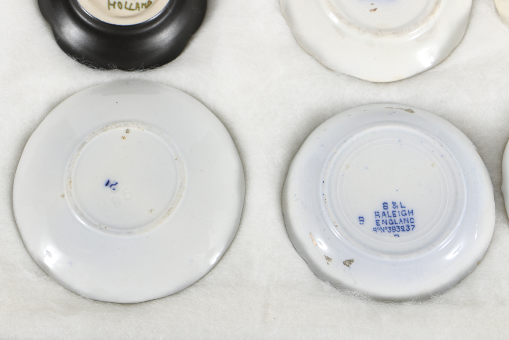 Twelve Porcelain Butter Pats In Glass Top Display Case