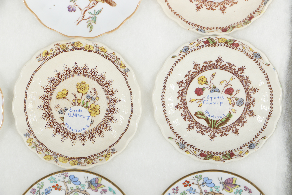 Twelve Porcelain Butter Pats In Glass Top Display Case