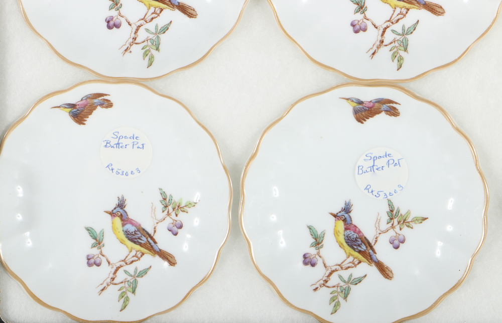 Twelve Porcelain Butter Pats In Glass Top Display Case