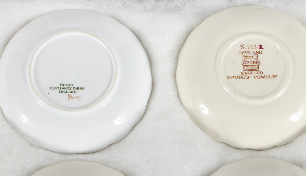 Twelve Porcelain Butter Pats In Glass Top Display Case