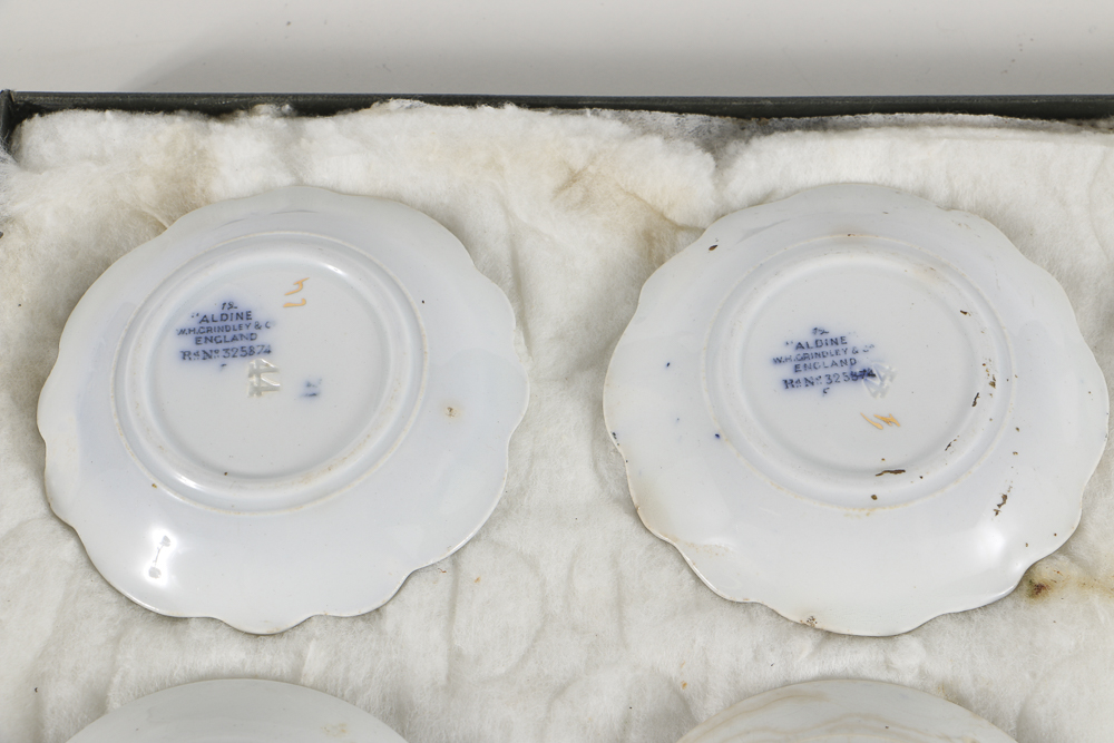 Twelve Porcelain Butter Pats In Glass Top Display Case