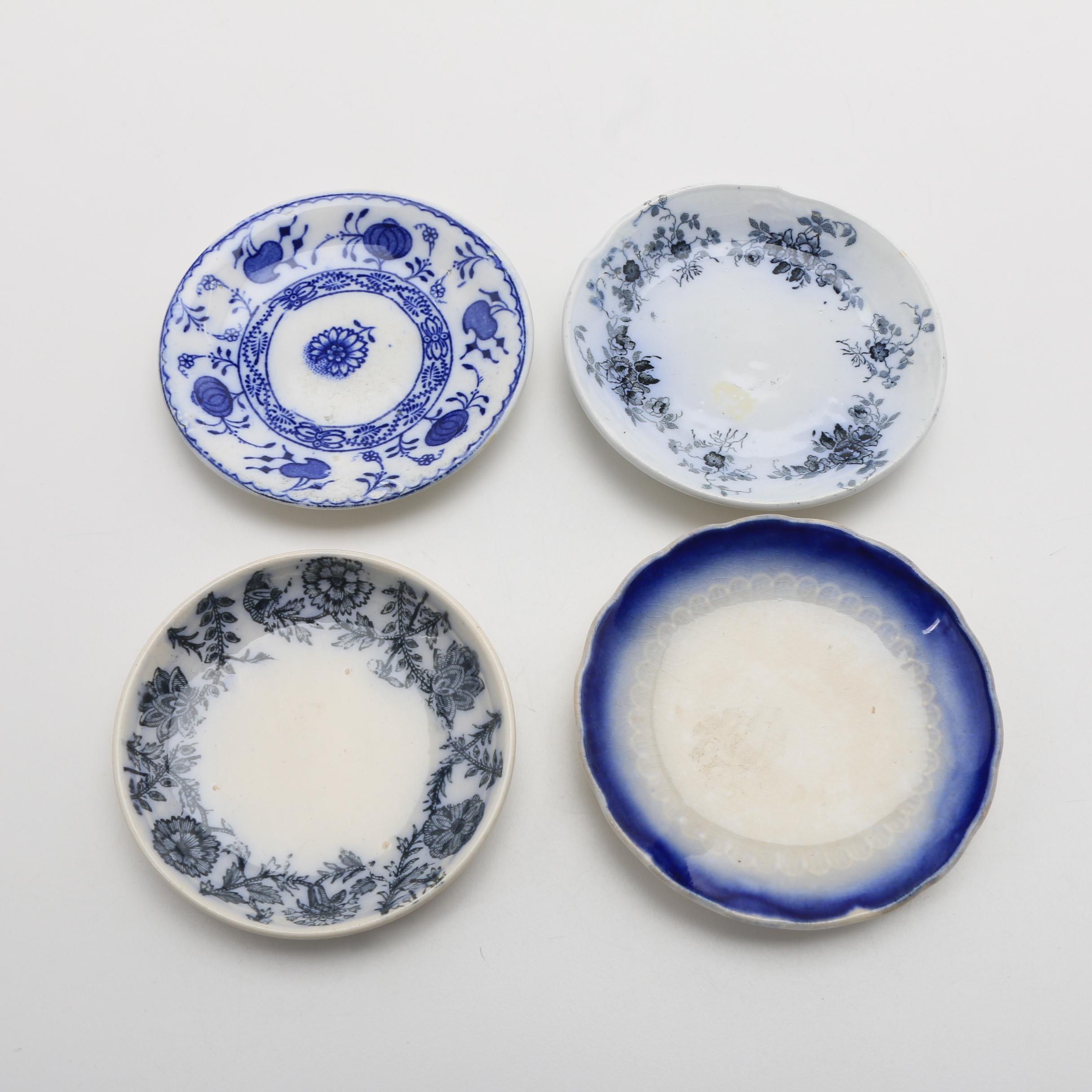 Twelve Porcelain Butter Pats In Glass Top Display Case