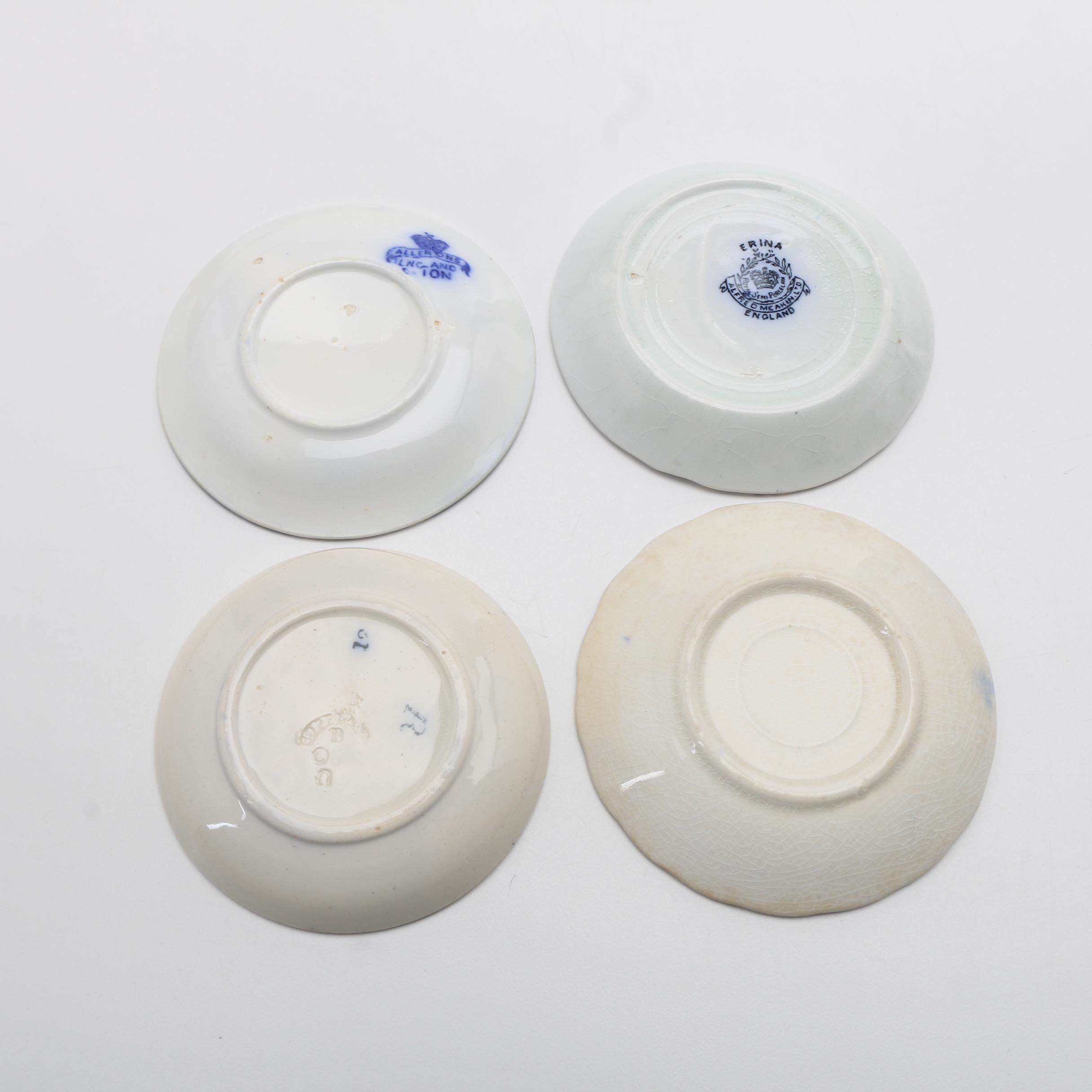 Twelve Porcelain Butter Pats In Glass Top Display Case