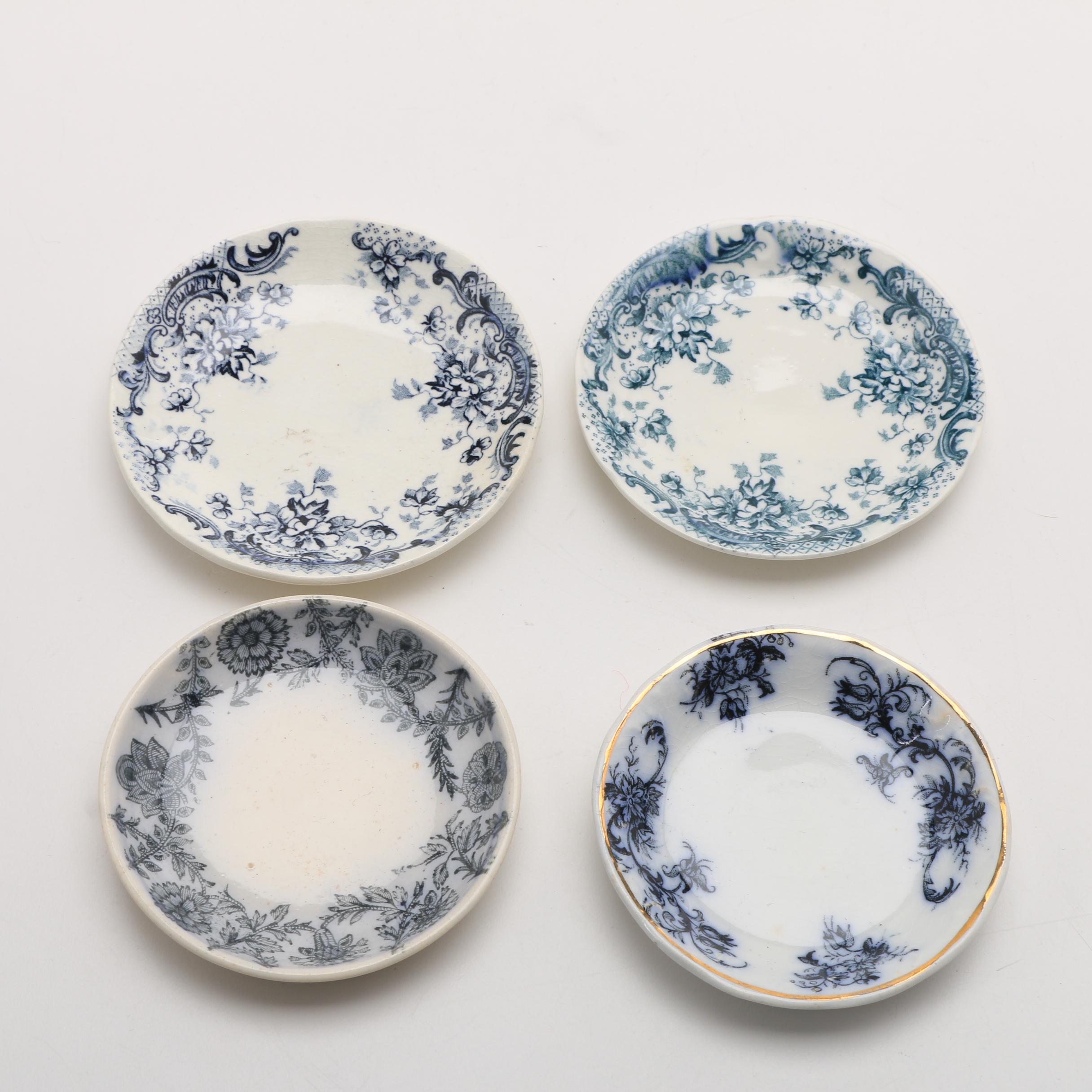 Twelve Porcelain Butter Pats In Glass Top Display Case