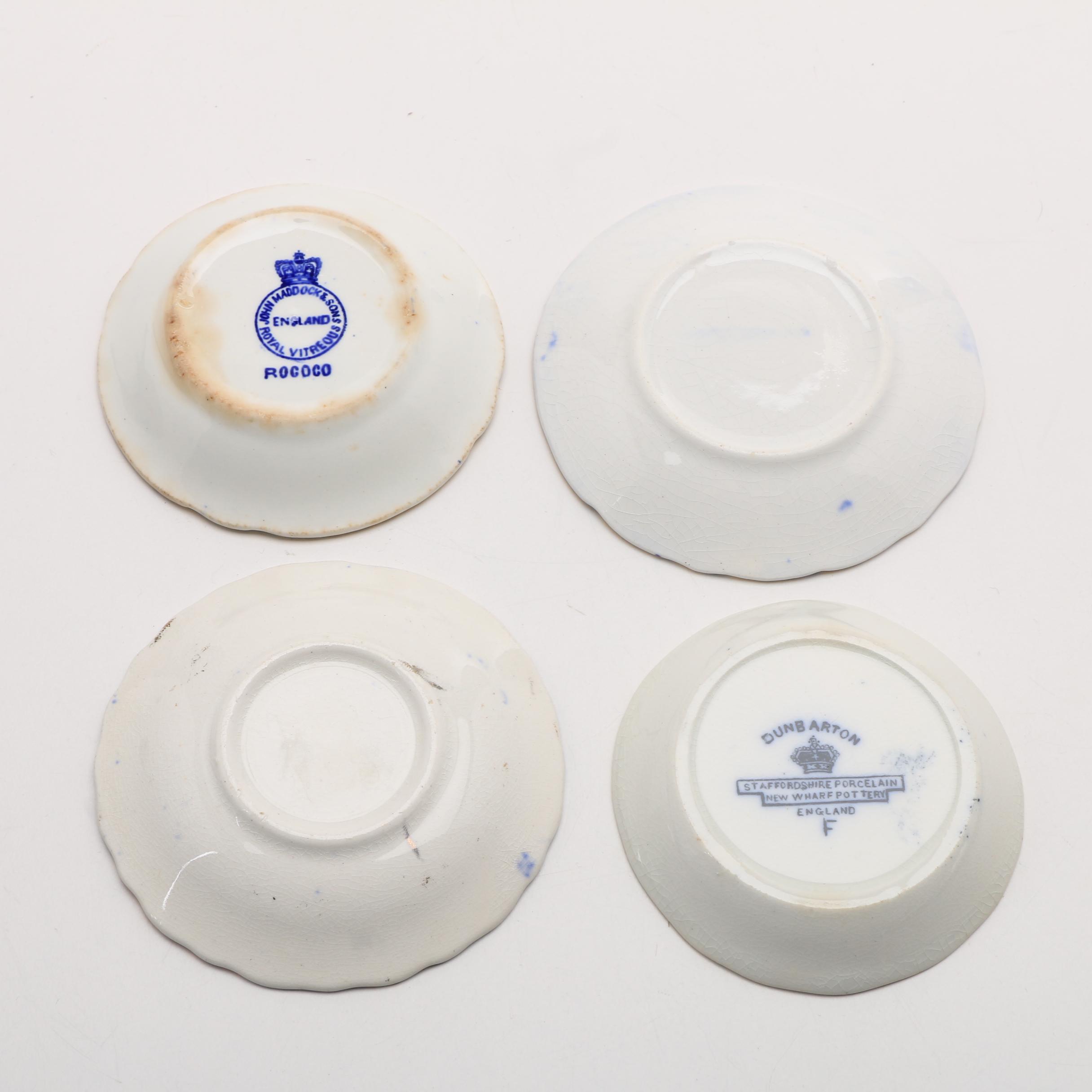 Twelve Porcelain Butter Pats In Glass Top Display Case