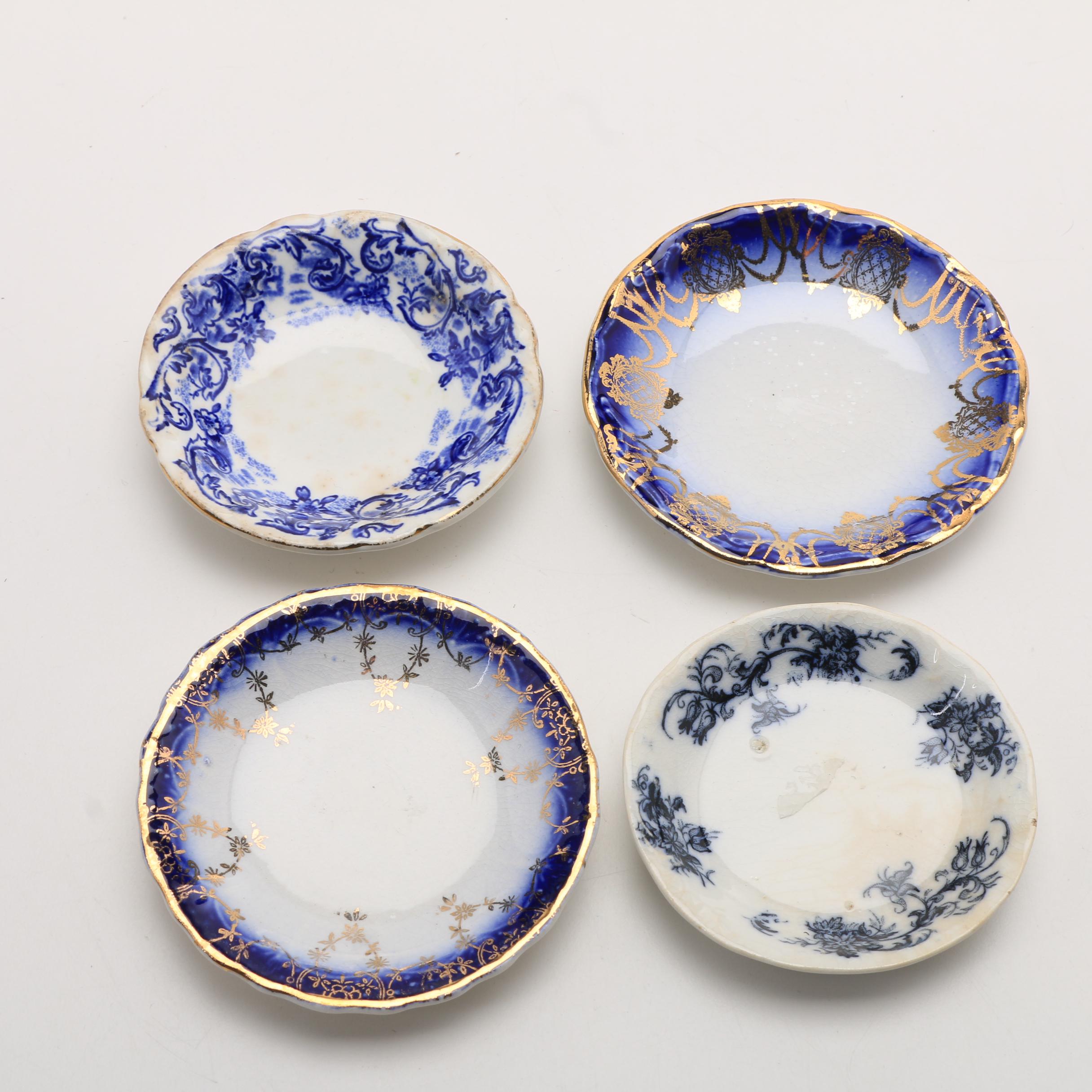 Twelve Porcelain Butter Pats In Glass Top Display Case