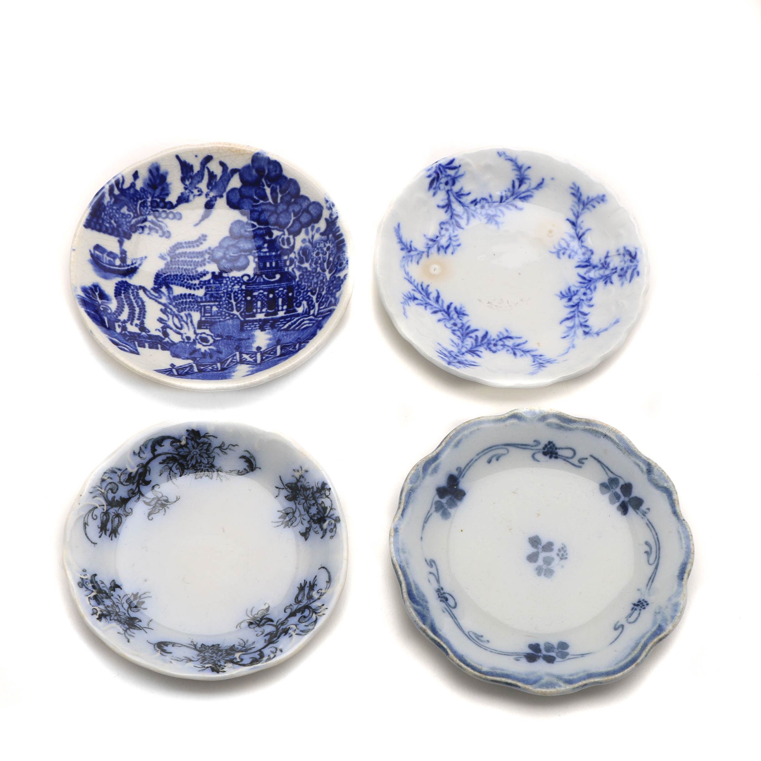 Twelve Porcelain Butter Pats In Glass Top Display Case