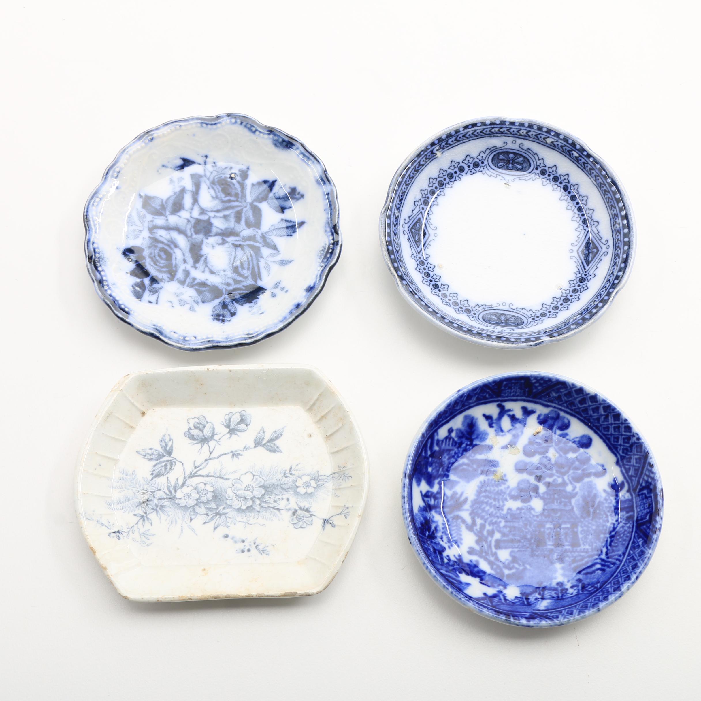 Twelve Porcelain Butter Pats In Glass Top Display Case