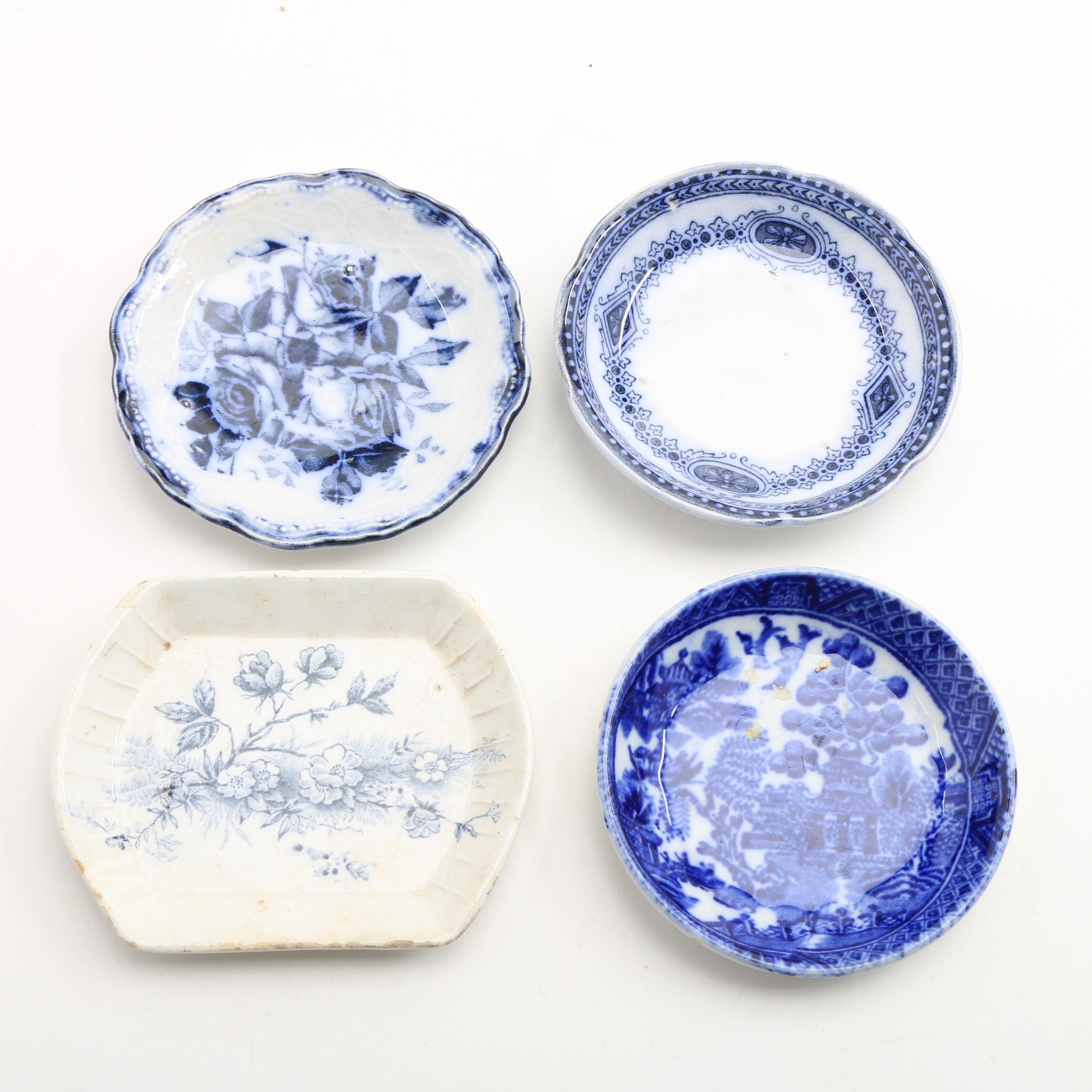 Twelve Porcelain Butter Pats In Glass Top Display Case