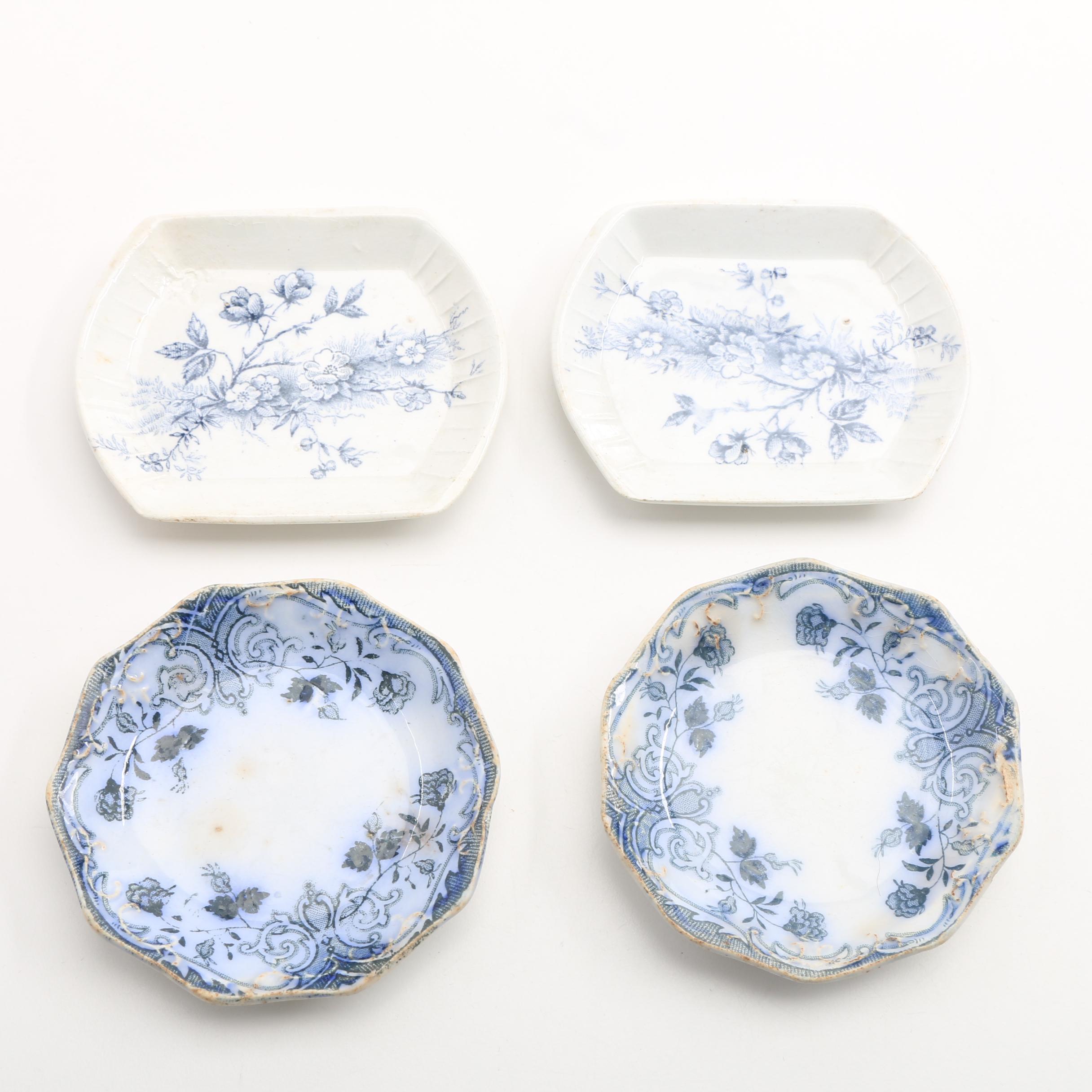 Twelve Porcelain Butter Pats In Glass Top Display Case