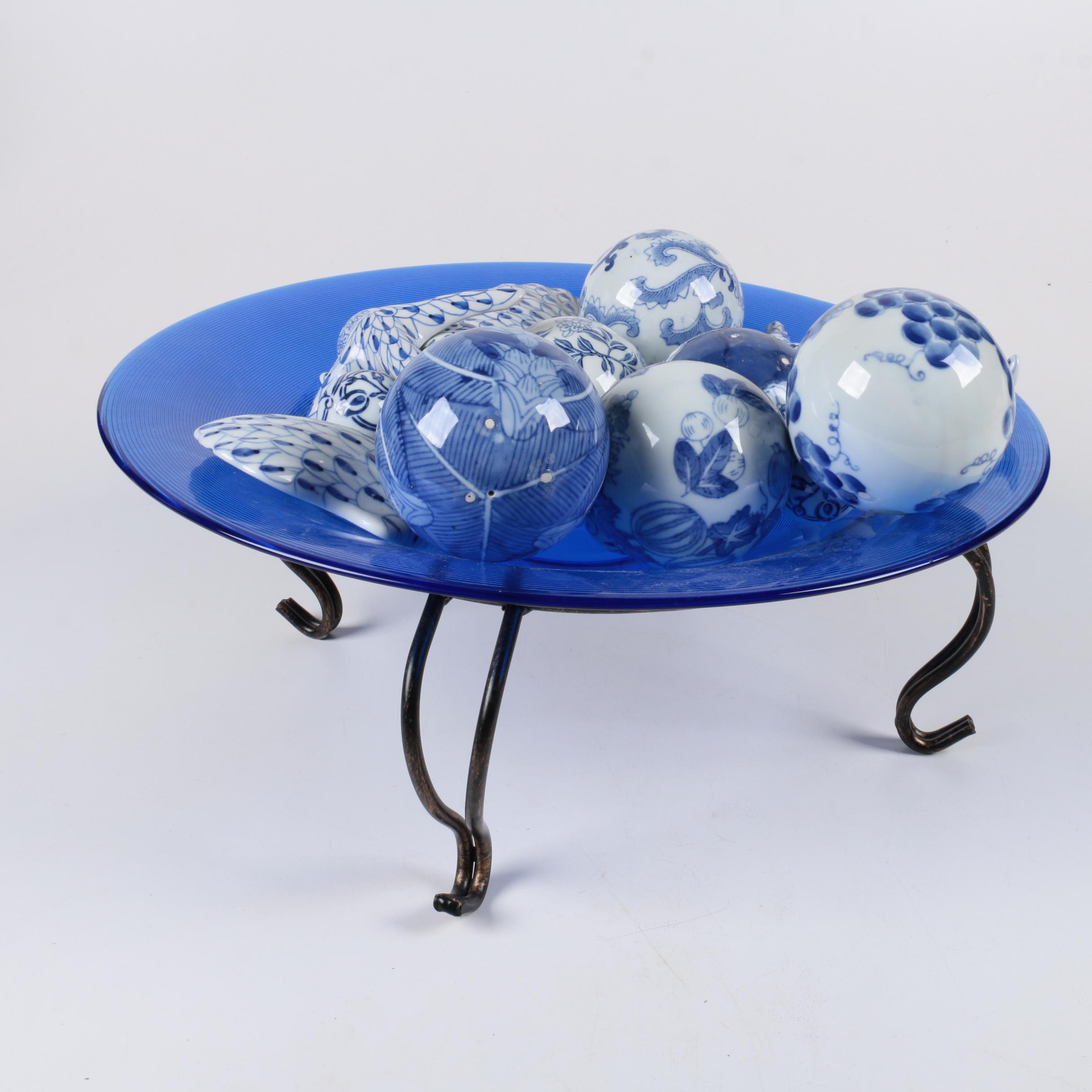 Assortment of Blue and White Ceramic Decor in Blue Glass Bowl
