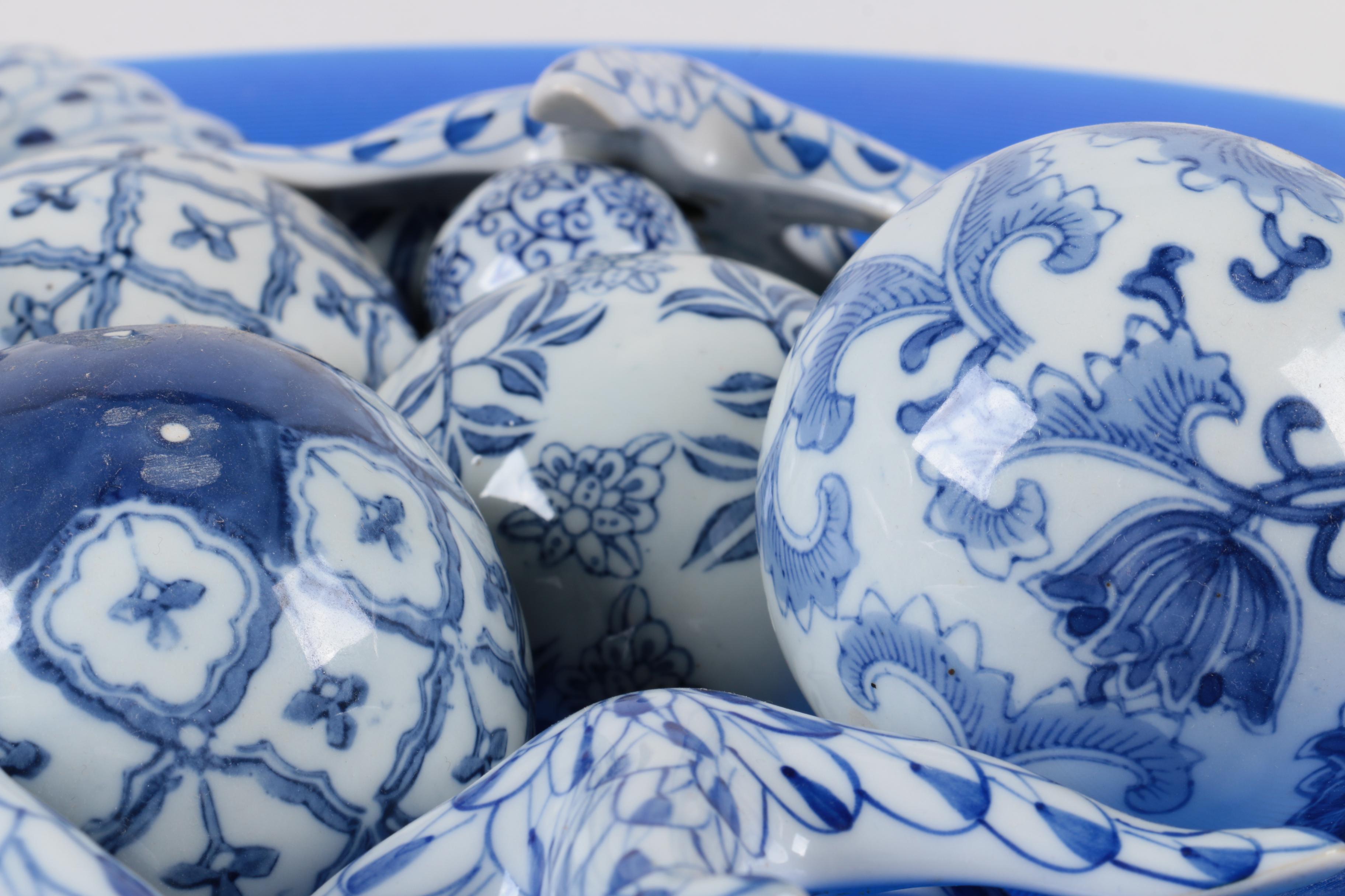 Assortment of Blue and White Ceramic Decor in Blue Glass Bowl