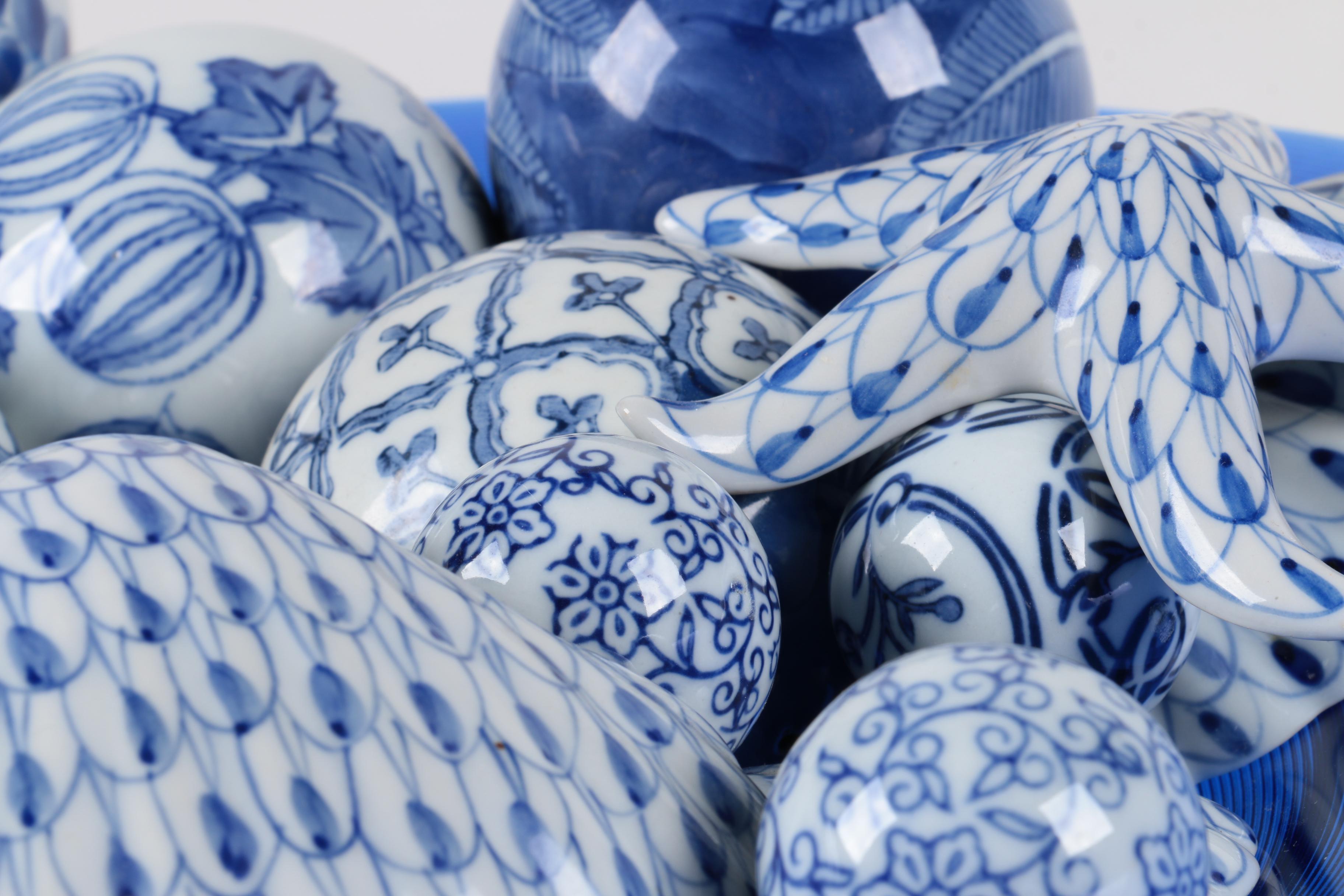 Assortment of Blue and White Ceramic Decor in Blue Glass Bowl