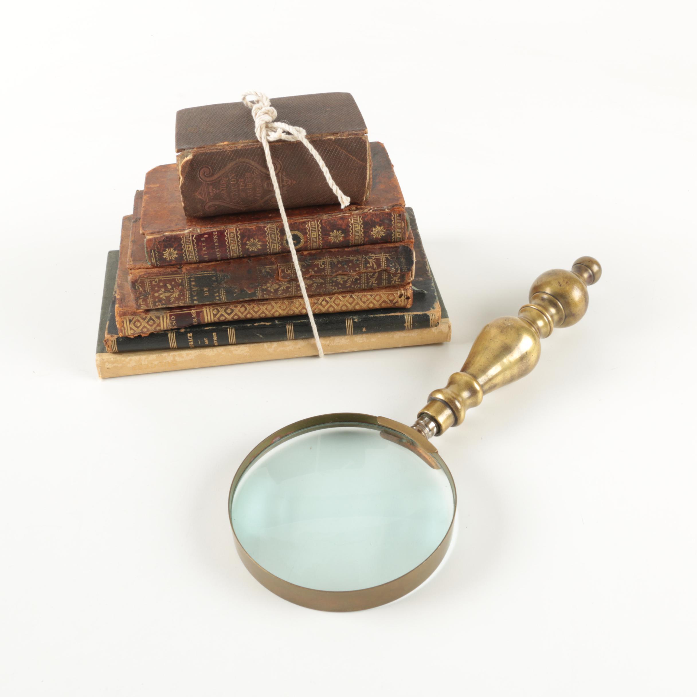 Six Antique Books and Magnifying Glass
