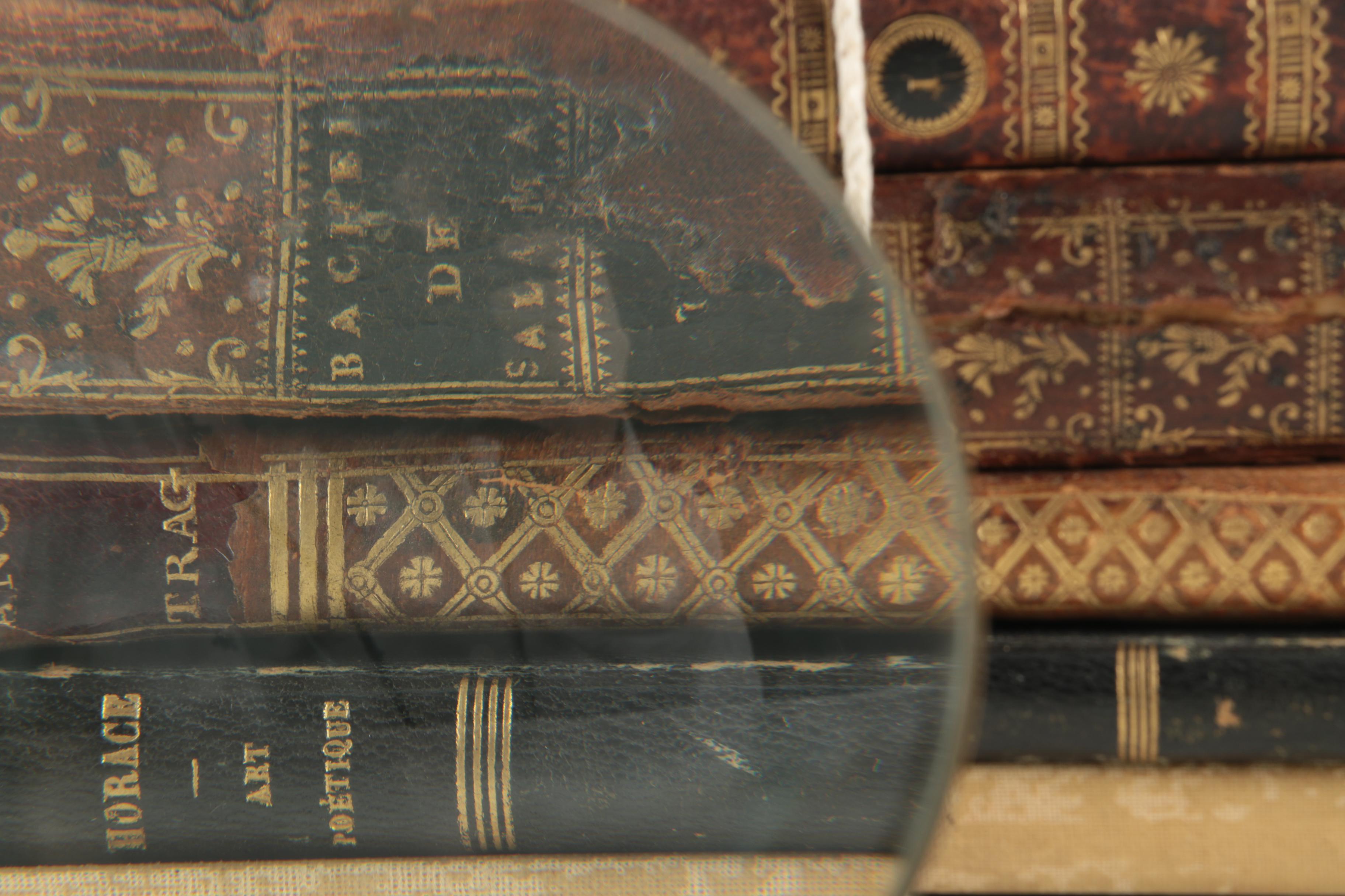 Six Antique Books and Magnifying Glass