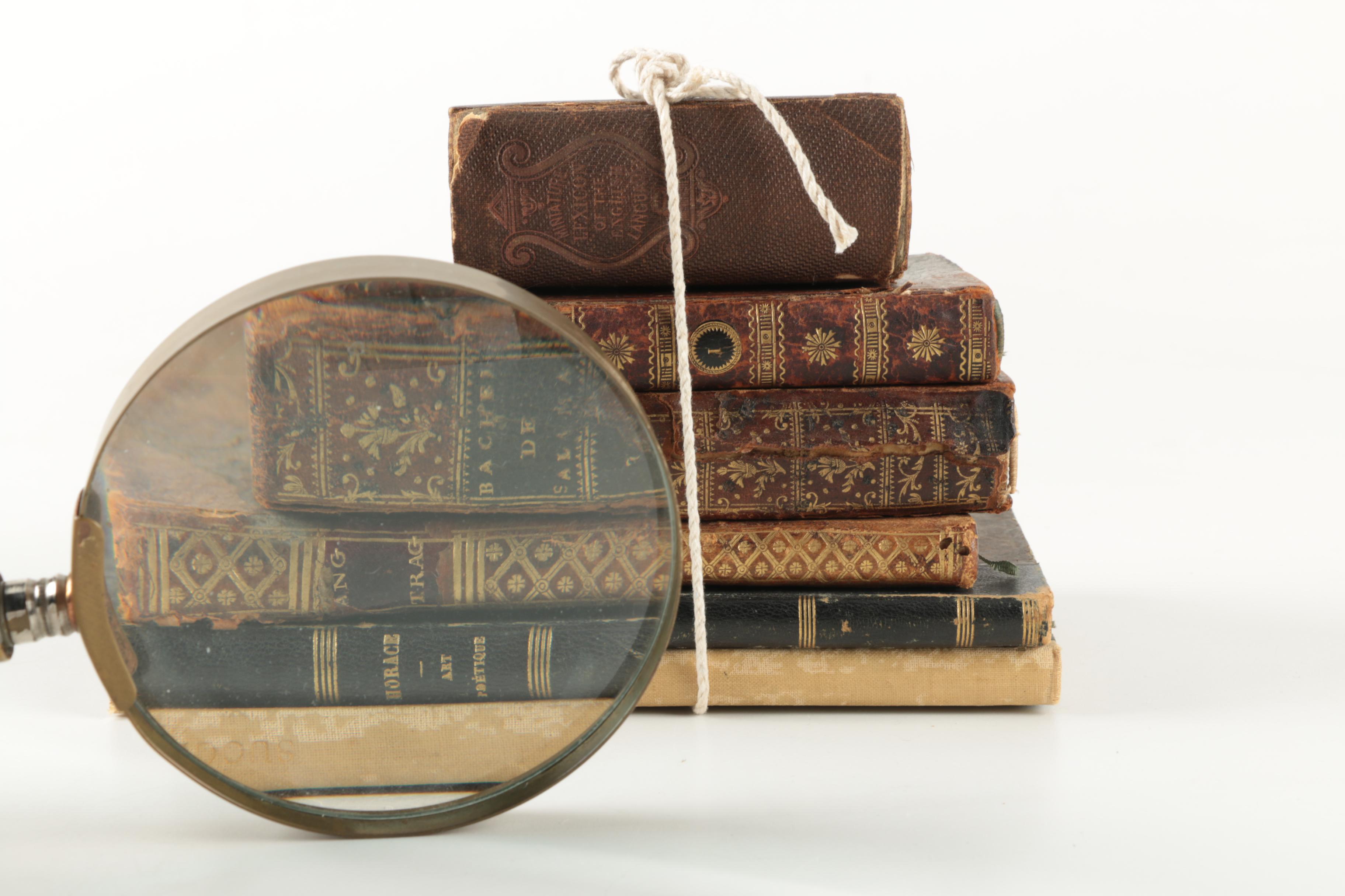 Six Antique Books and Magnifying Glass