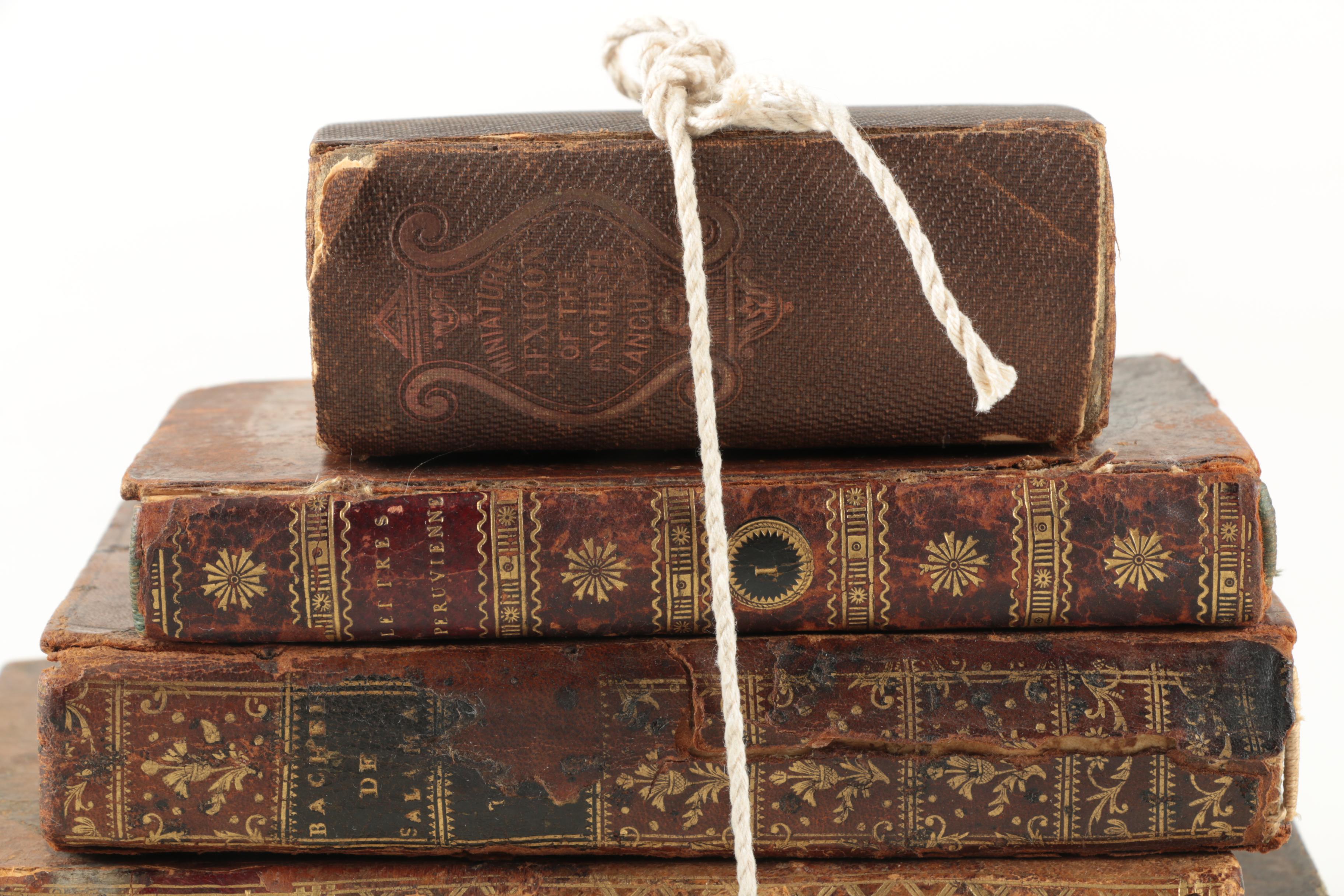 Six Antique Books and Magnifying Glass