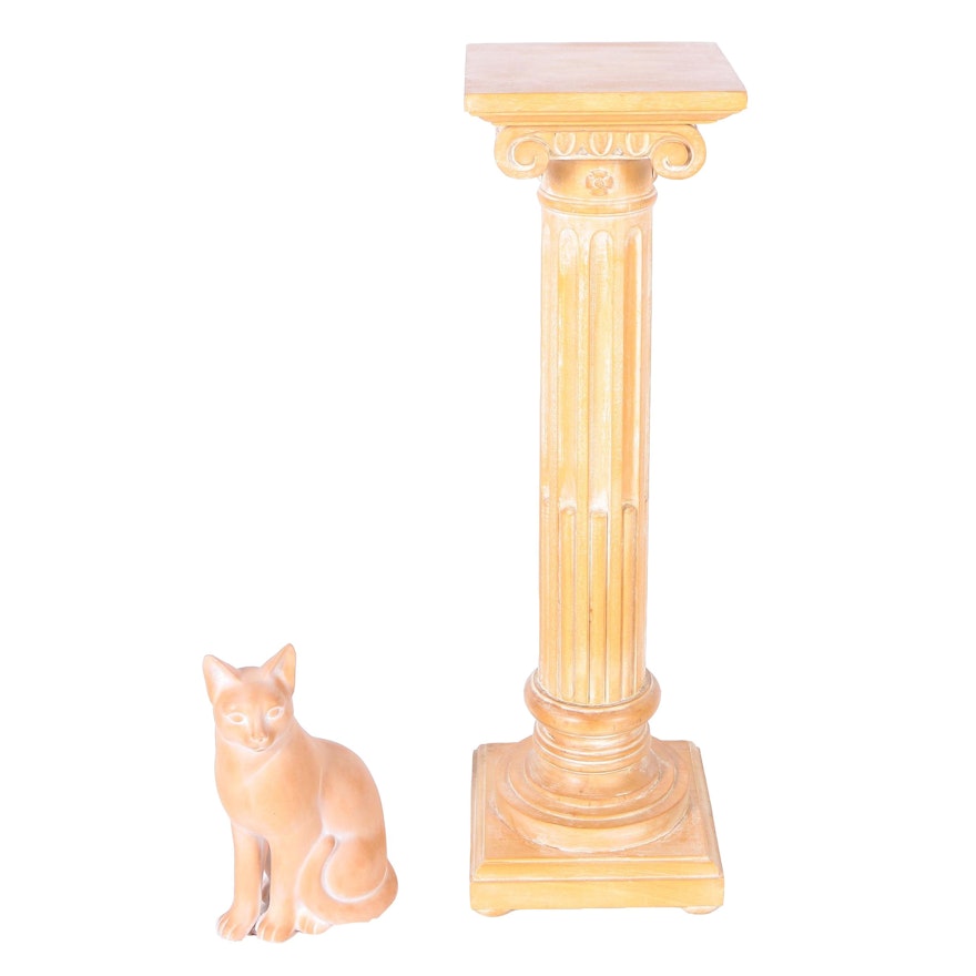 A Column Shaped Wooden Stand and Terracotta Cat