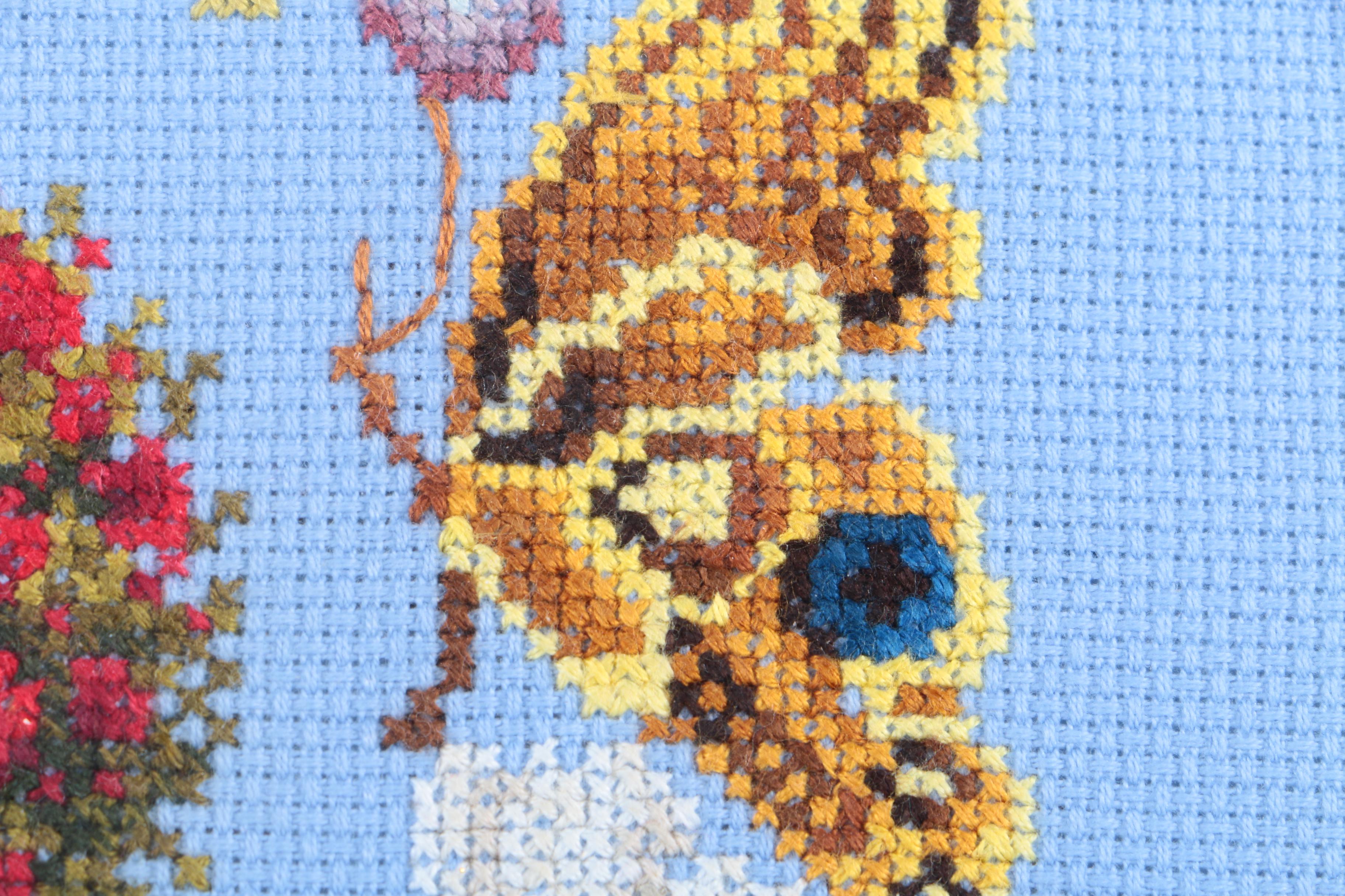 Cross-Stitch Embroidery of a Woman Surrounded by a Wreath