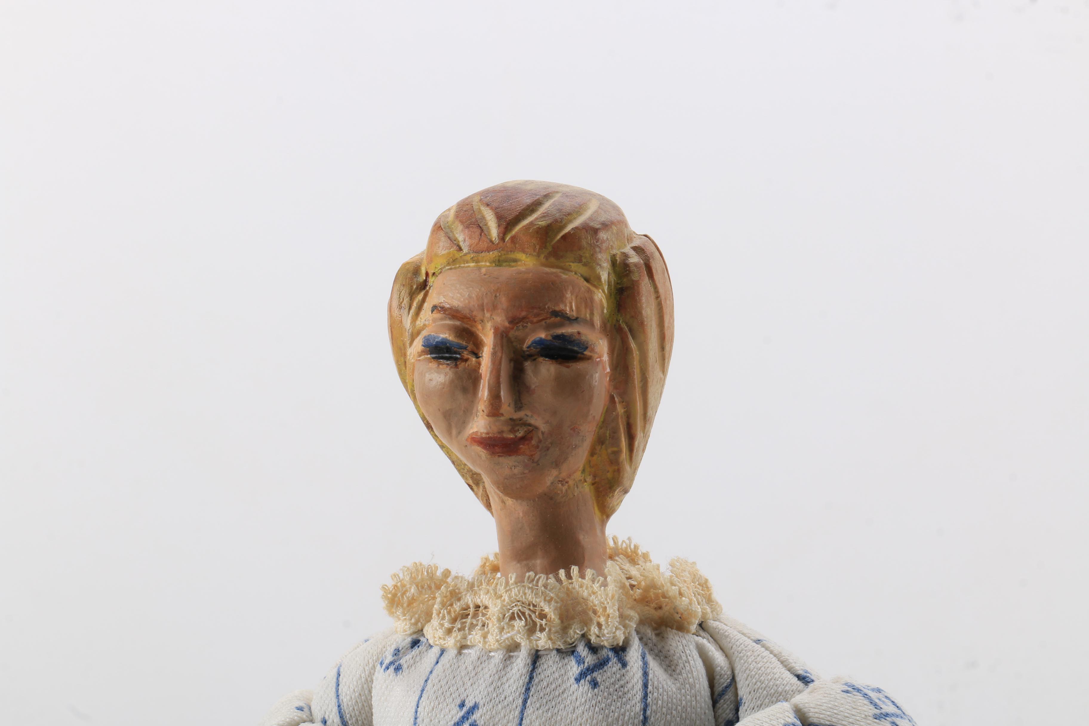 Carved Wood Doll Featuring a Detailed and Painted Face