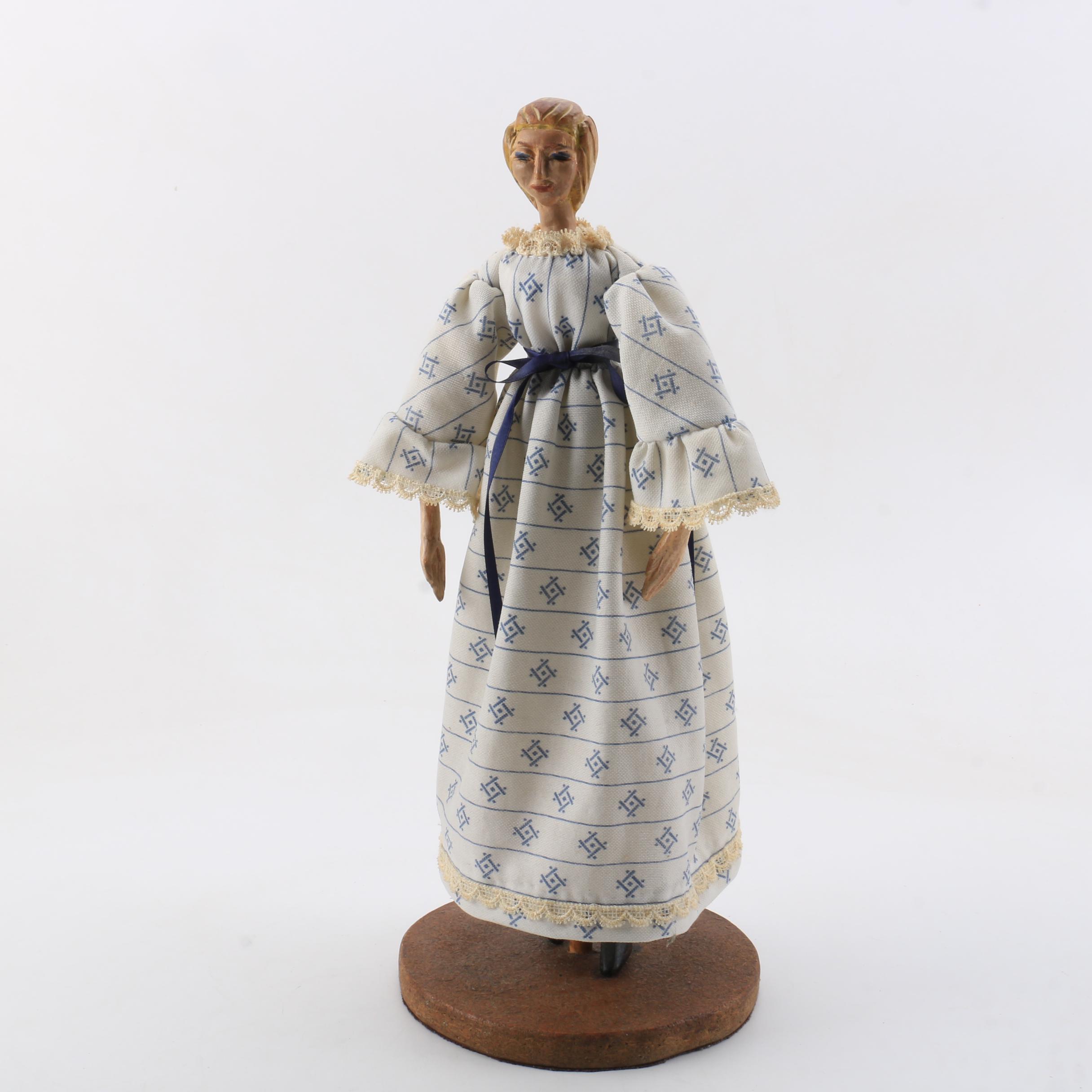 Carved Wood Doll Featuring a Detailed and Painted Face