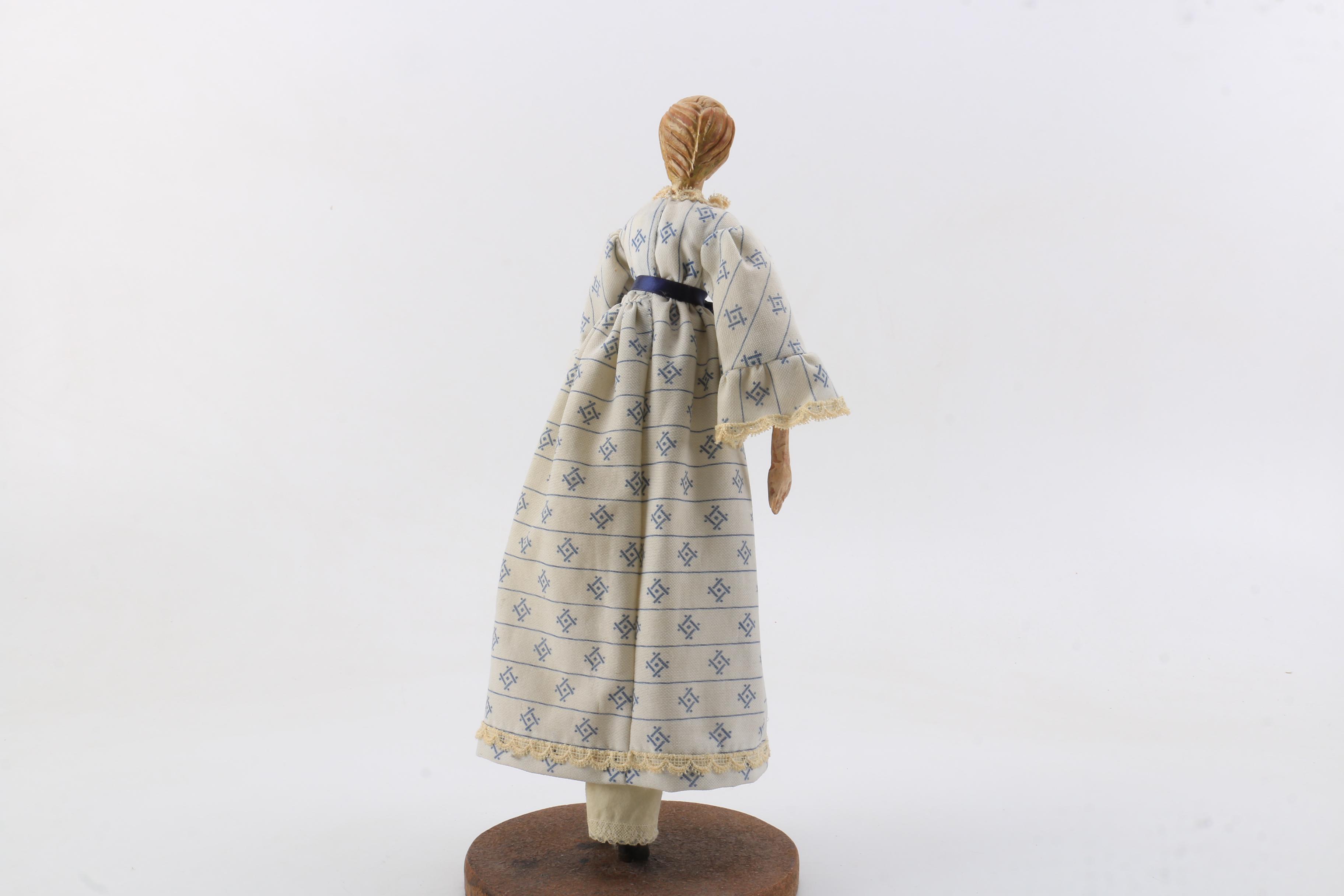 Carved Wood Doll Featuring a Detailed and Painted Face