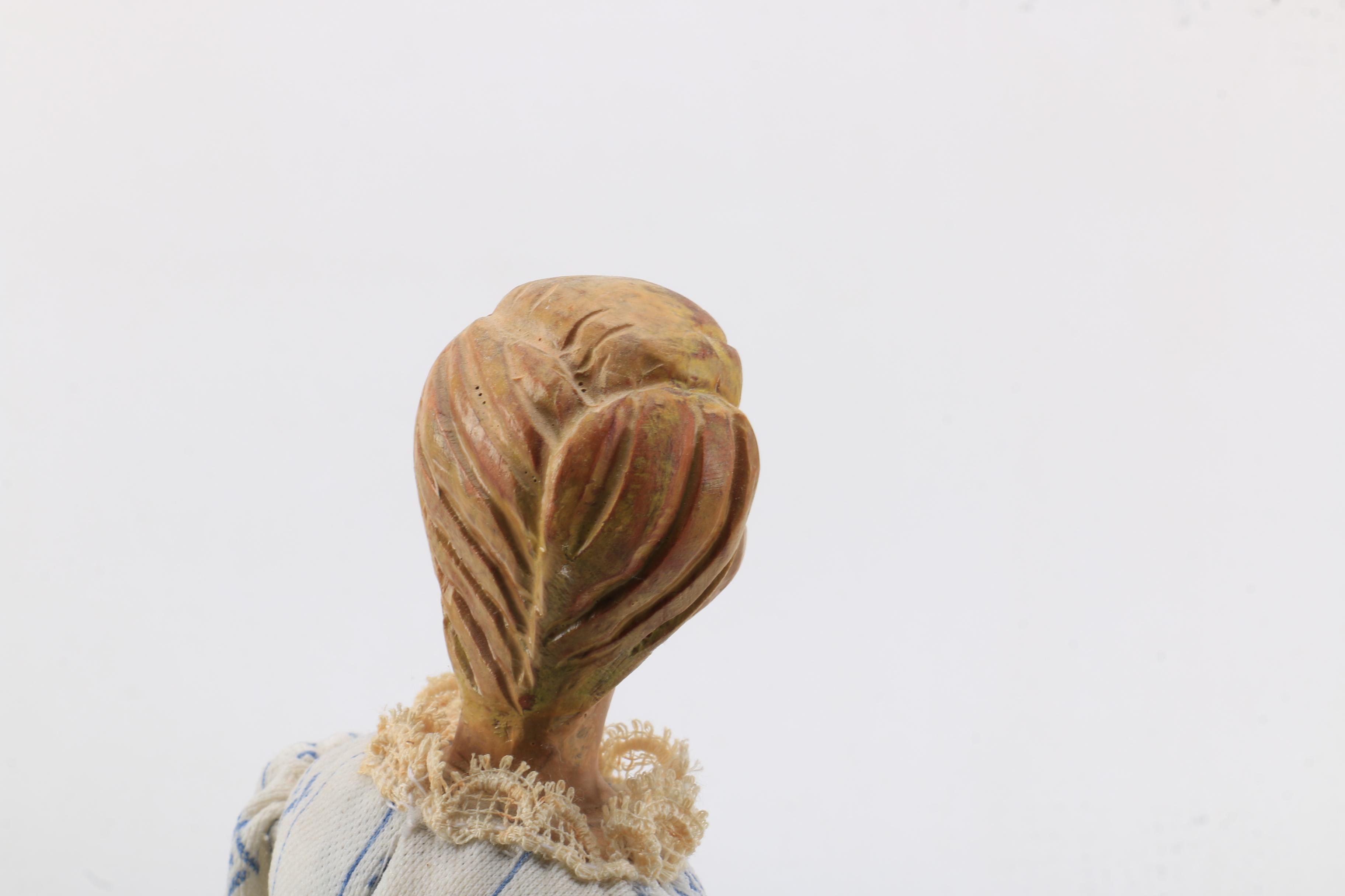 Carved Wood Doll Featuring a Detailed and Painted Face