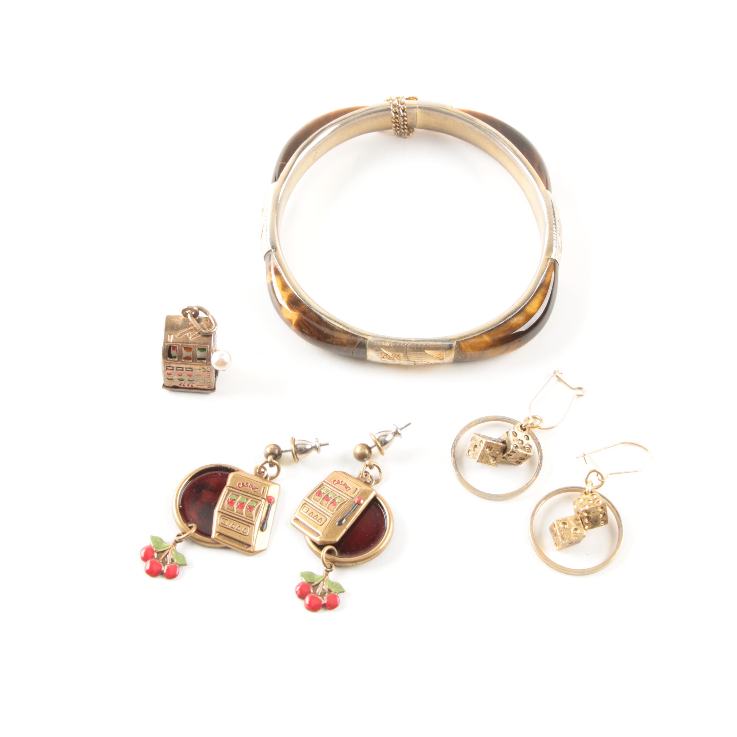 Gold Toned Costume Jewelry Featuring an Articulated Charm and Imitation Pearl