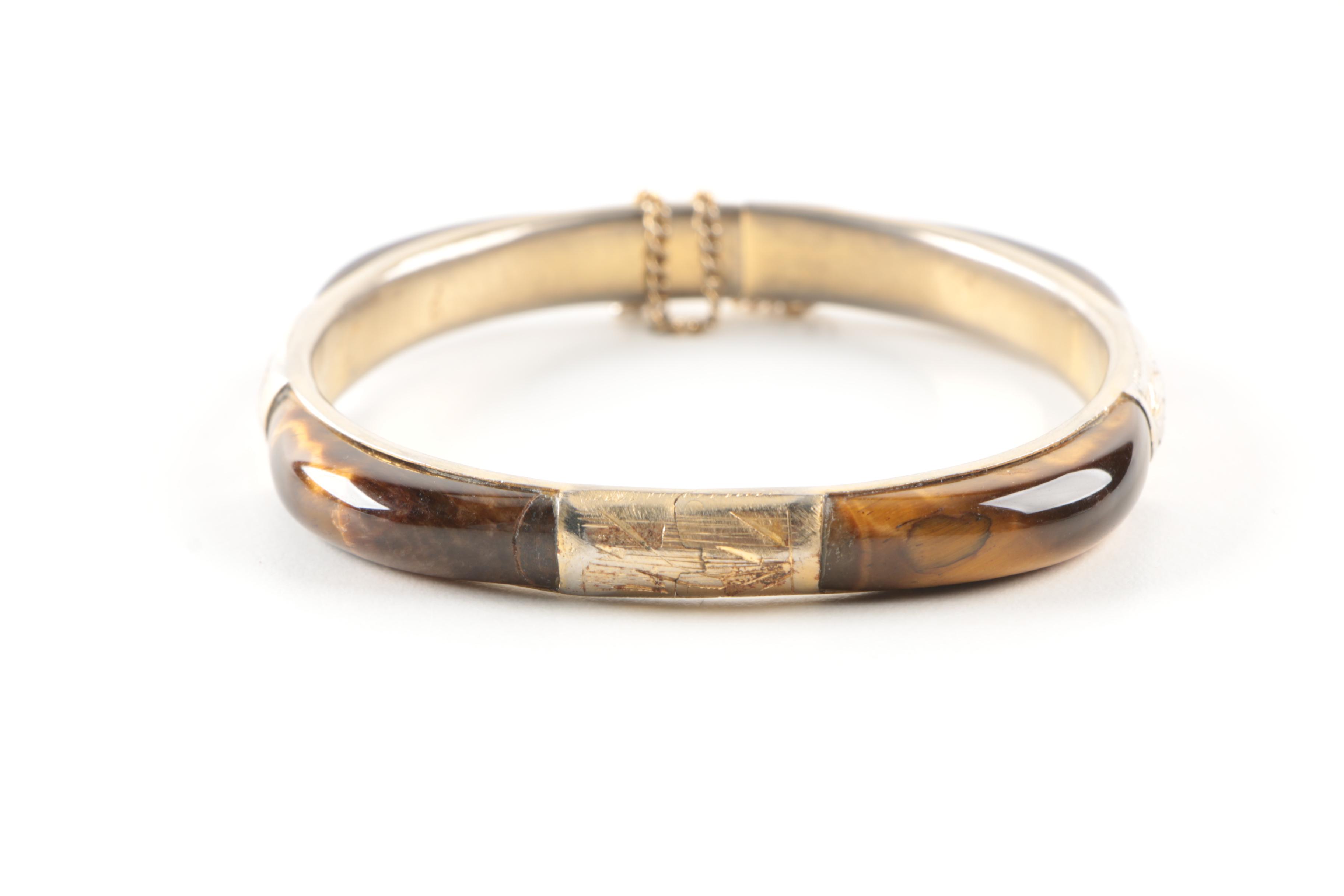 Gold Toned Costume Jewelry Featuring an Articulated Charm and Imitation Pearl