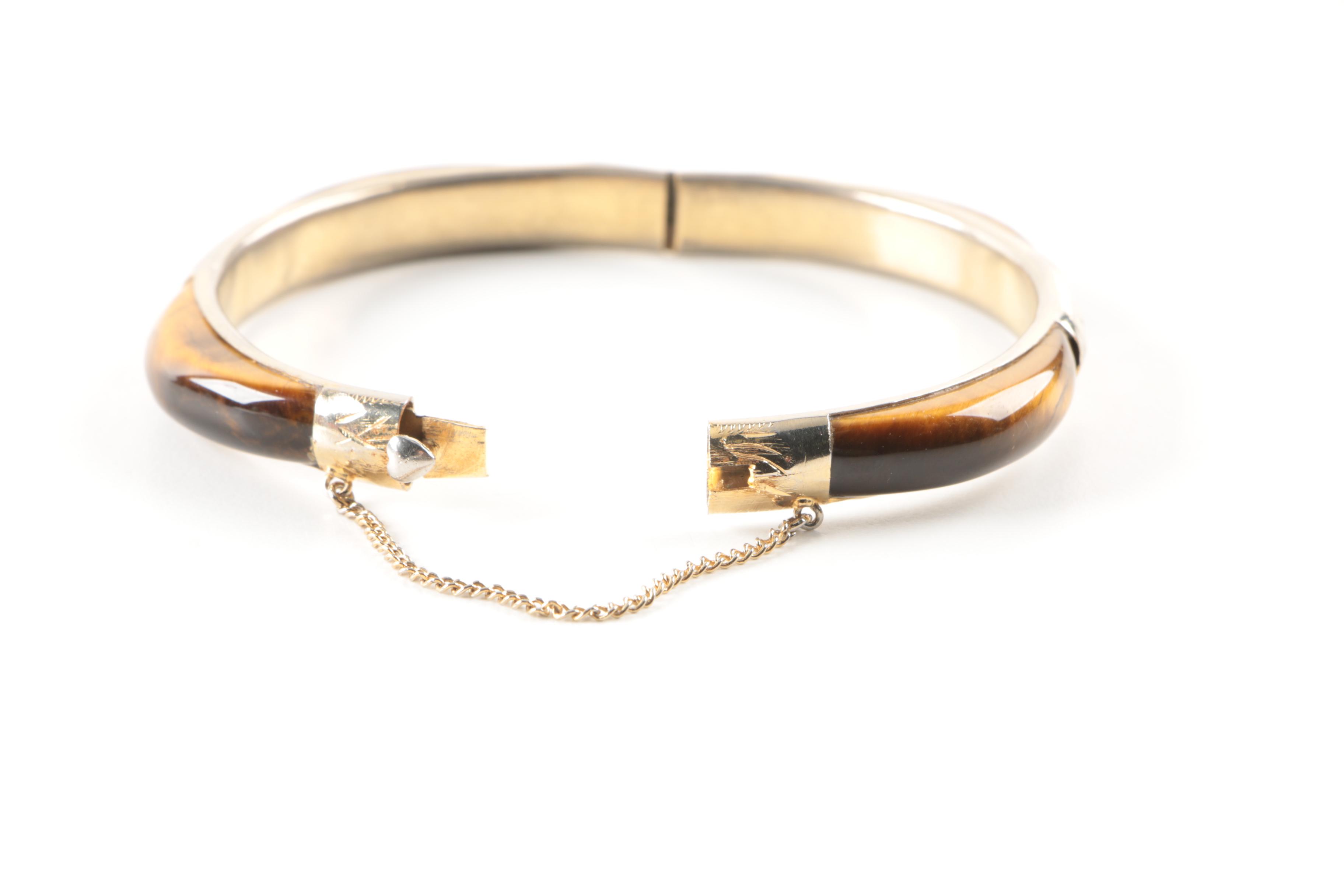 Gold Toned Costume Jewelry Featuring an Articulated Charm and Imitation Pearl