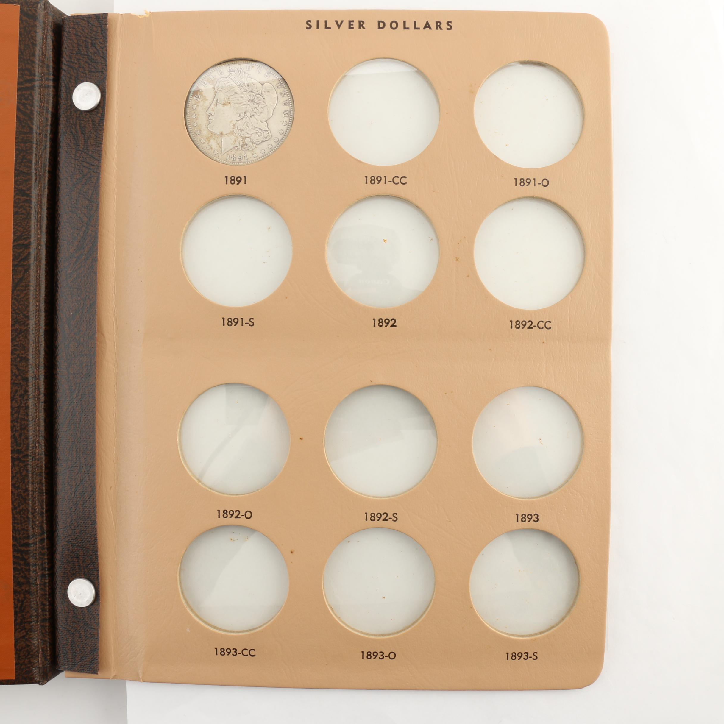 Four Morgan Silver Dollars in a Dansco Album