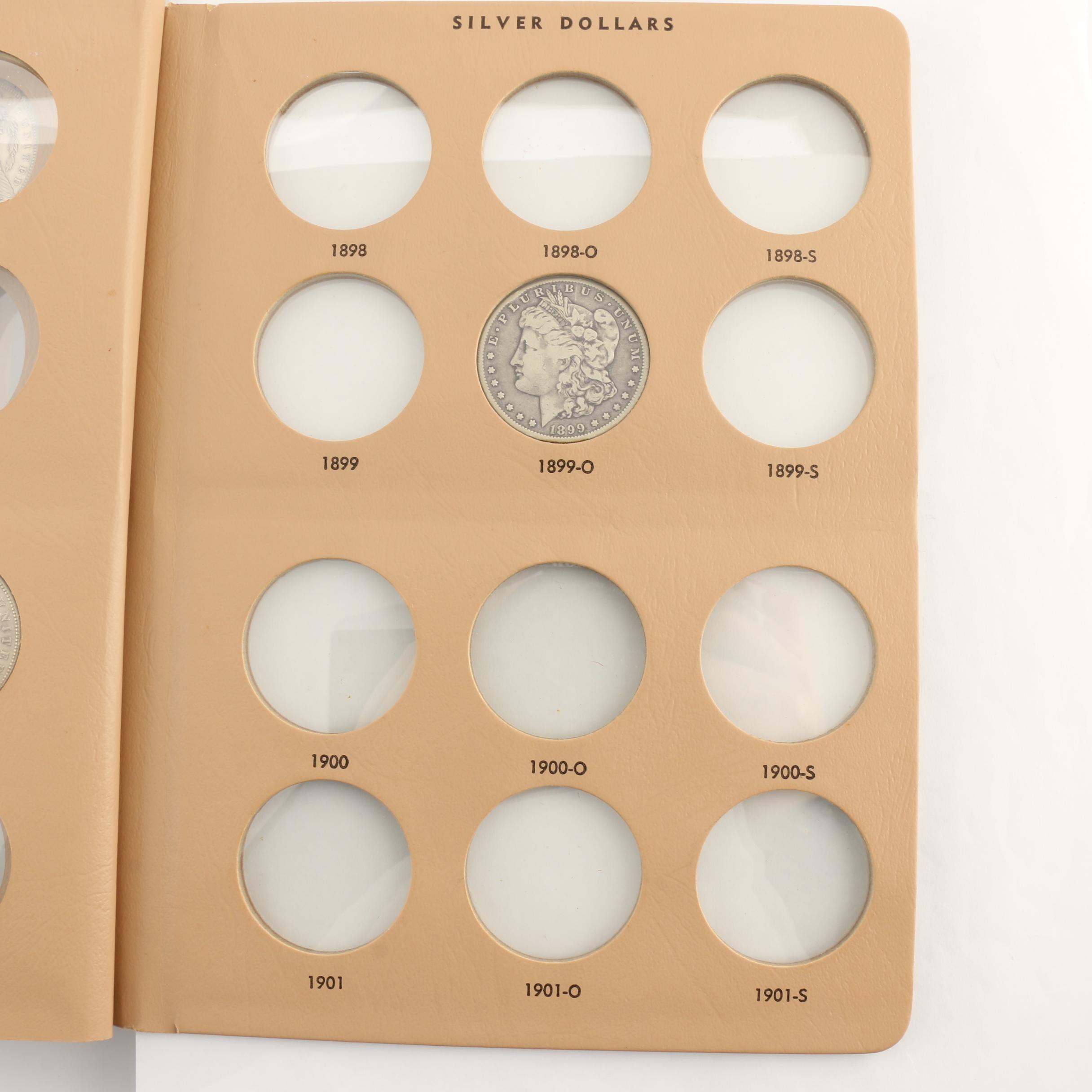 Four Morgan Silver Dollars in a Dansco Album