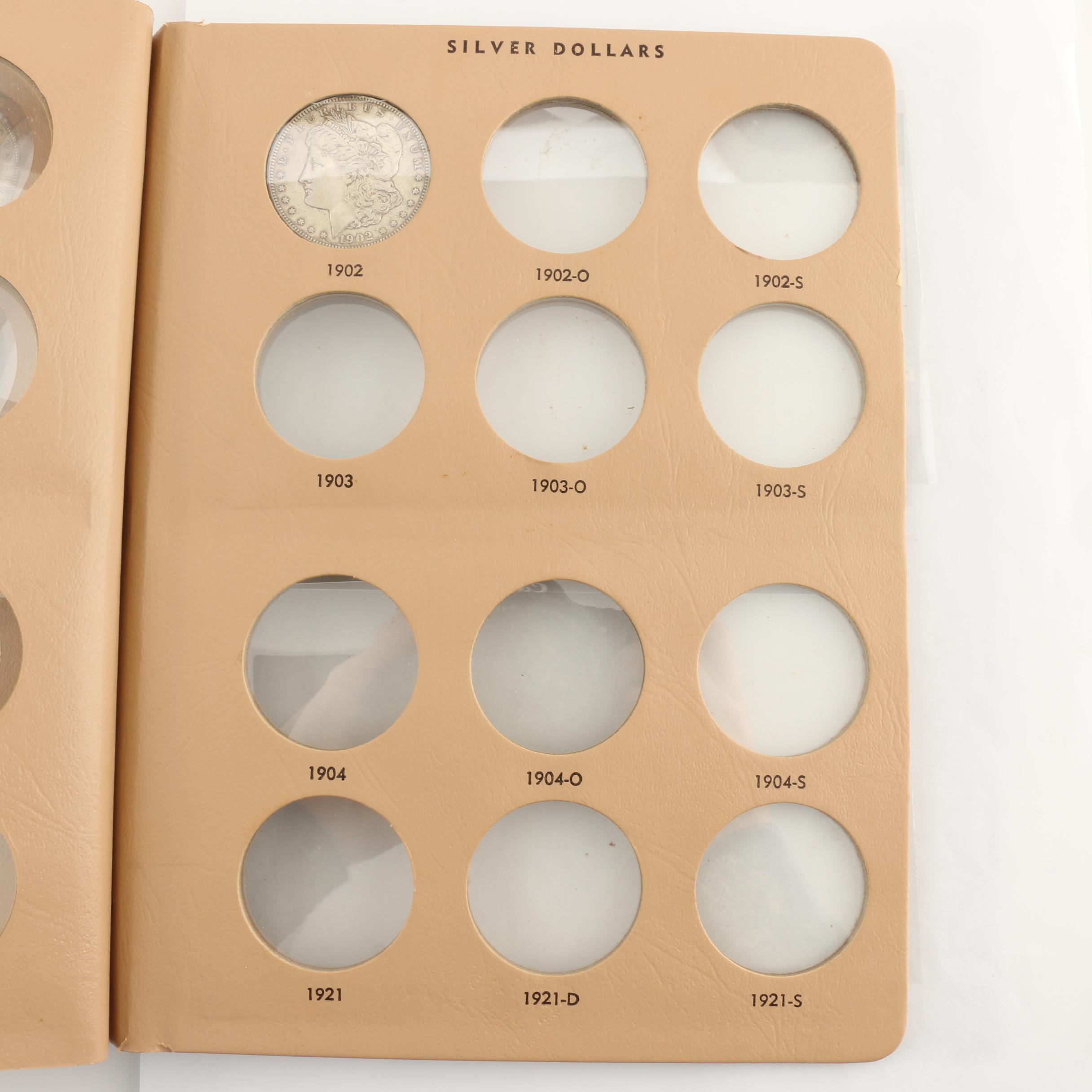 Four Morgan Silver Dollars in a Dansco Album