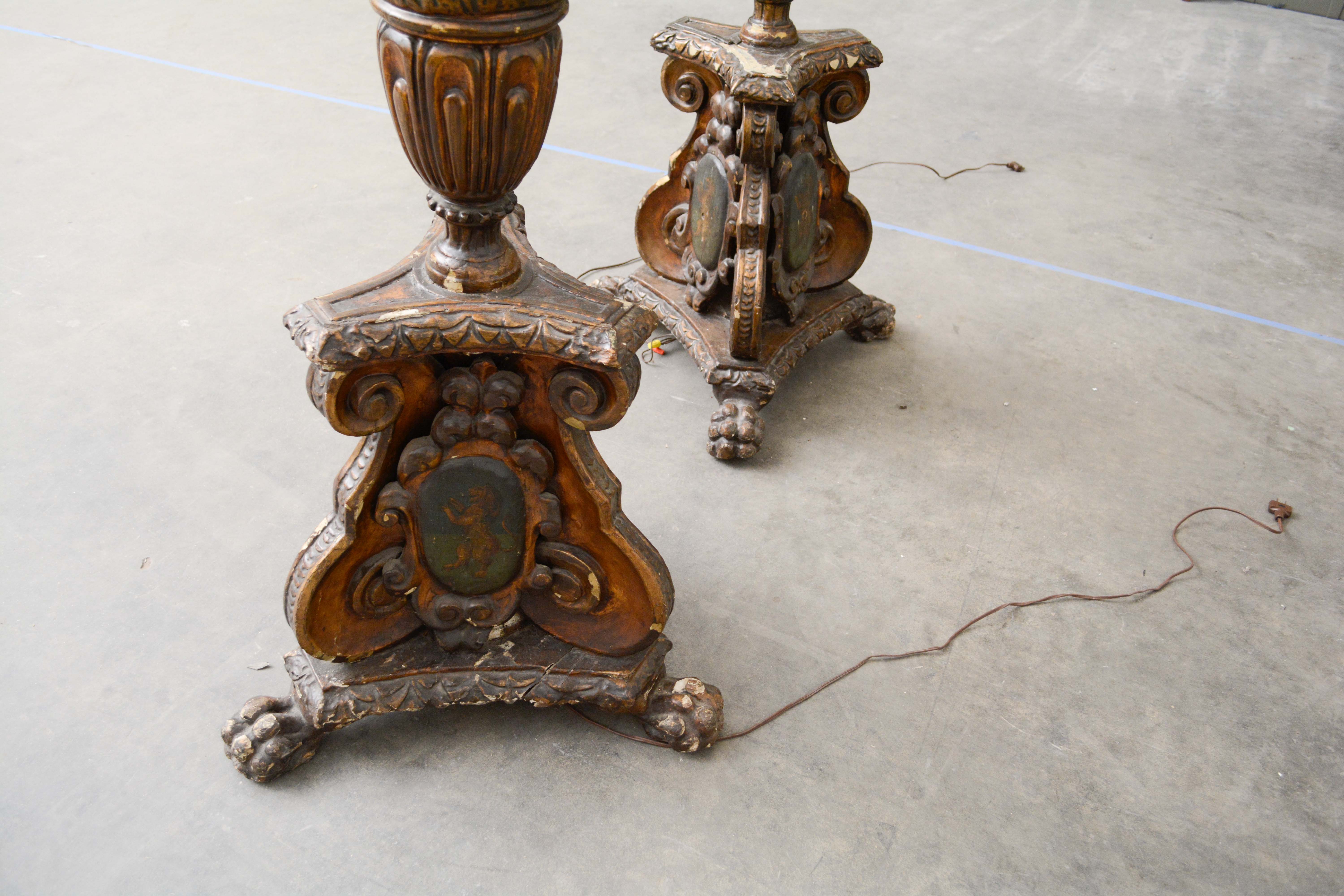 Ornately Carved Wooden Light Standards Featuring Heraldic Panels and Paw Feet
