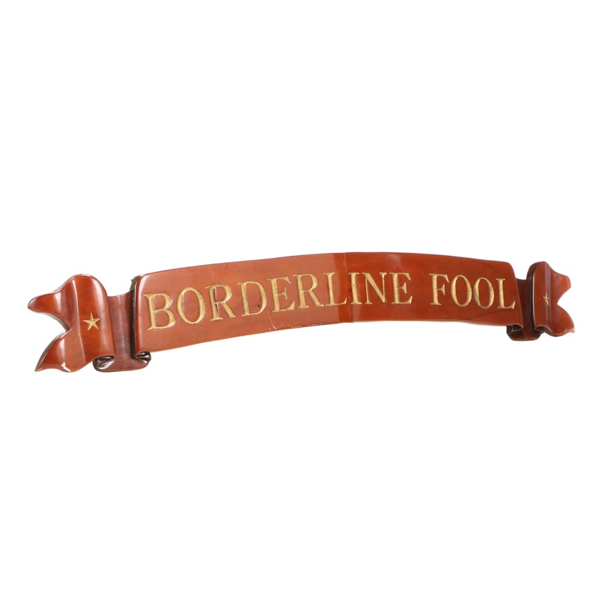 "Borderline Fool", Carved and Parcel-Gilt Ship's Ribbon-Form Quarterboard