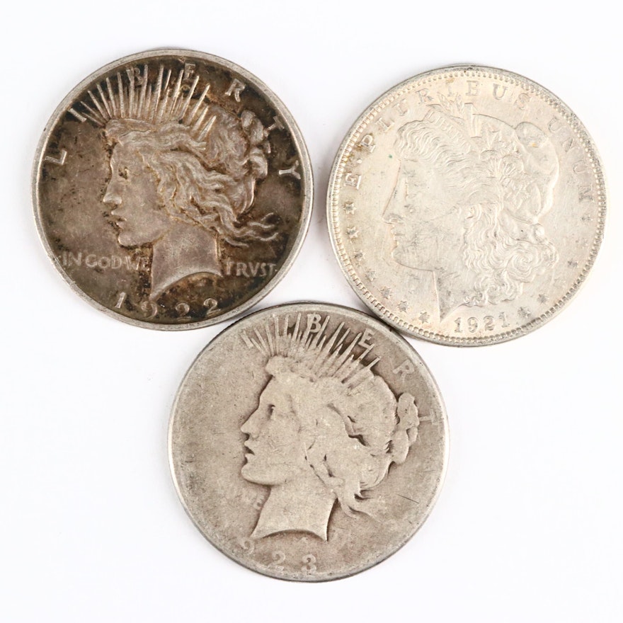 One Morgan and Two Peace Silver Dollars with Vintage Advertising Stickers