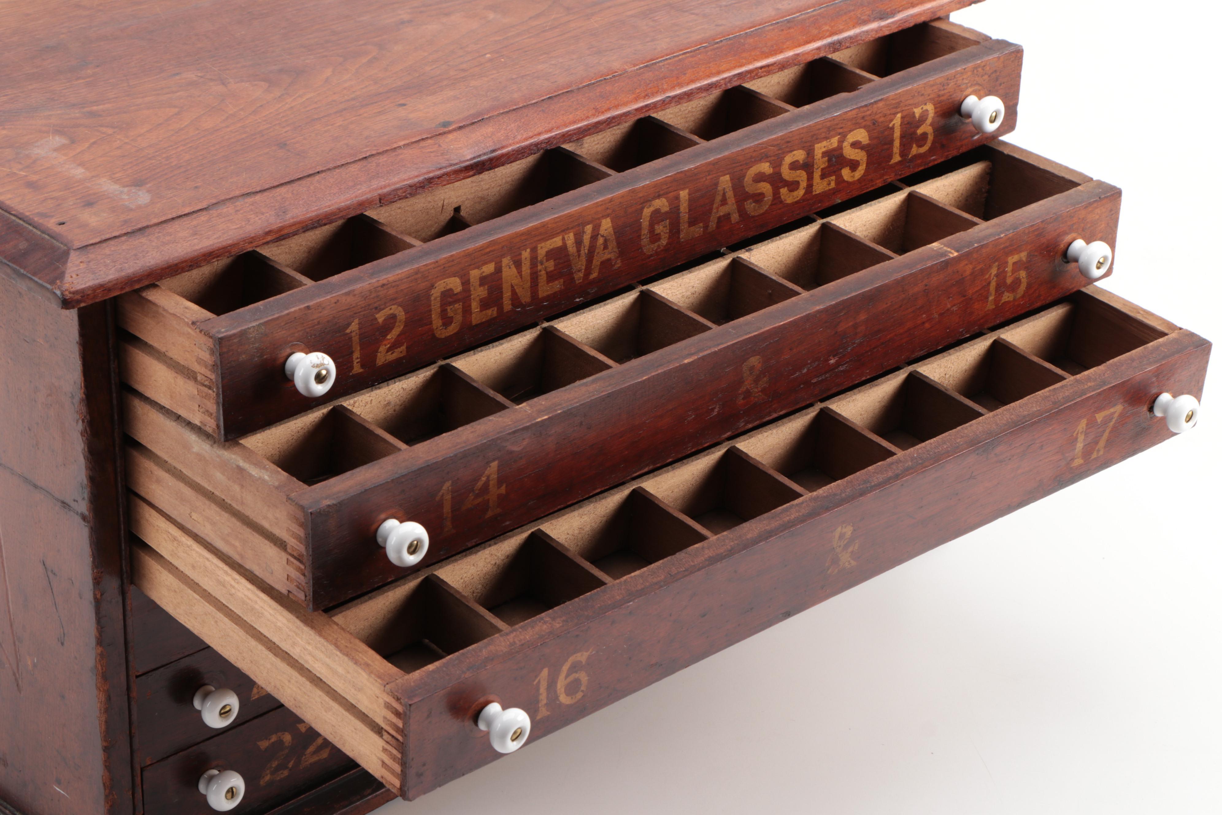 "GENEVA GLASSES" Gilt-Stenciled Walnut Six-Drawer Cabinet, circa 1900