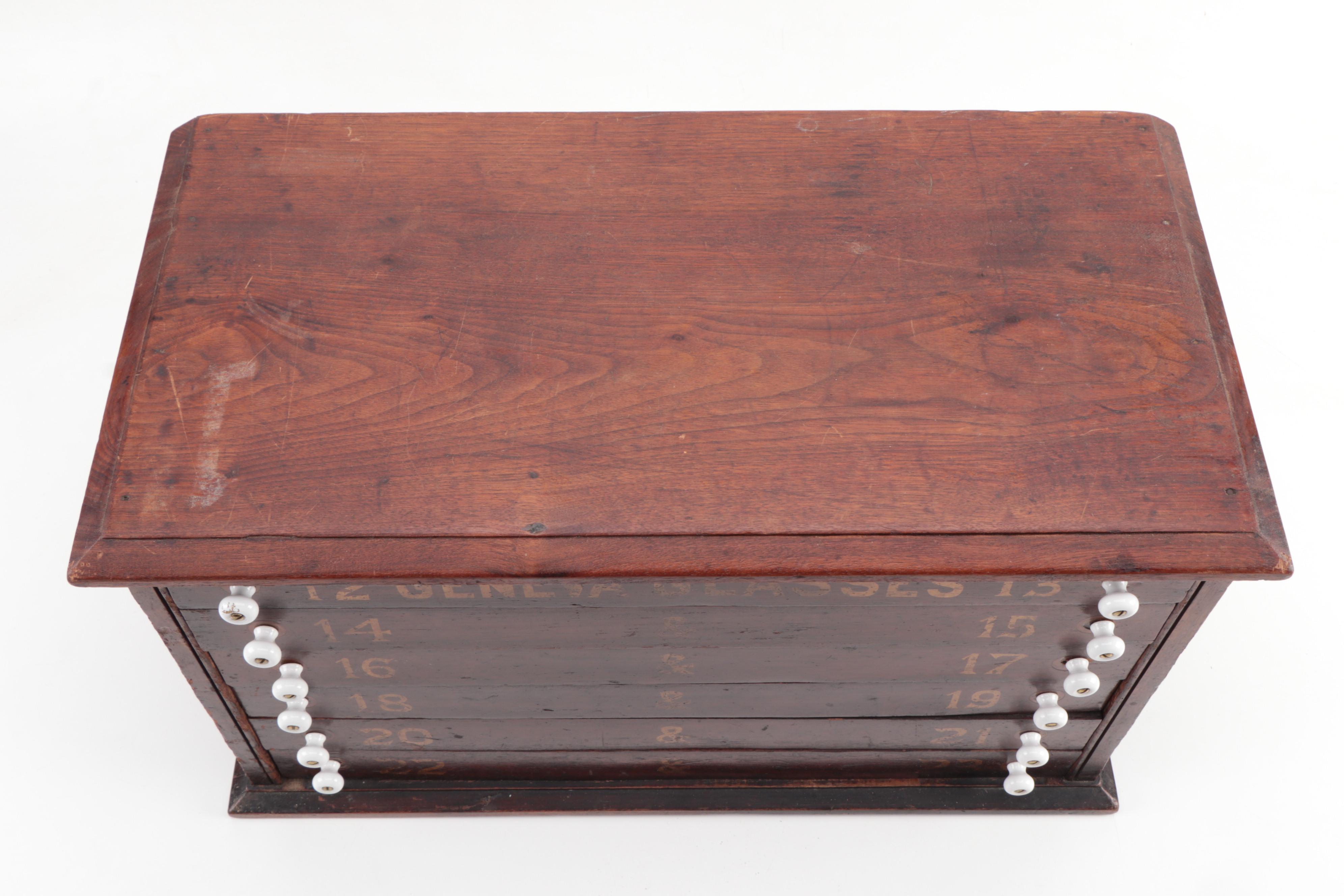 "GENEVA GLASSES" Gilt-Stenciled Walnut Six-Drawer Cabinet, circa 1900