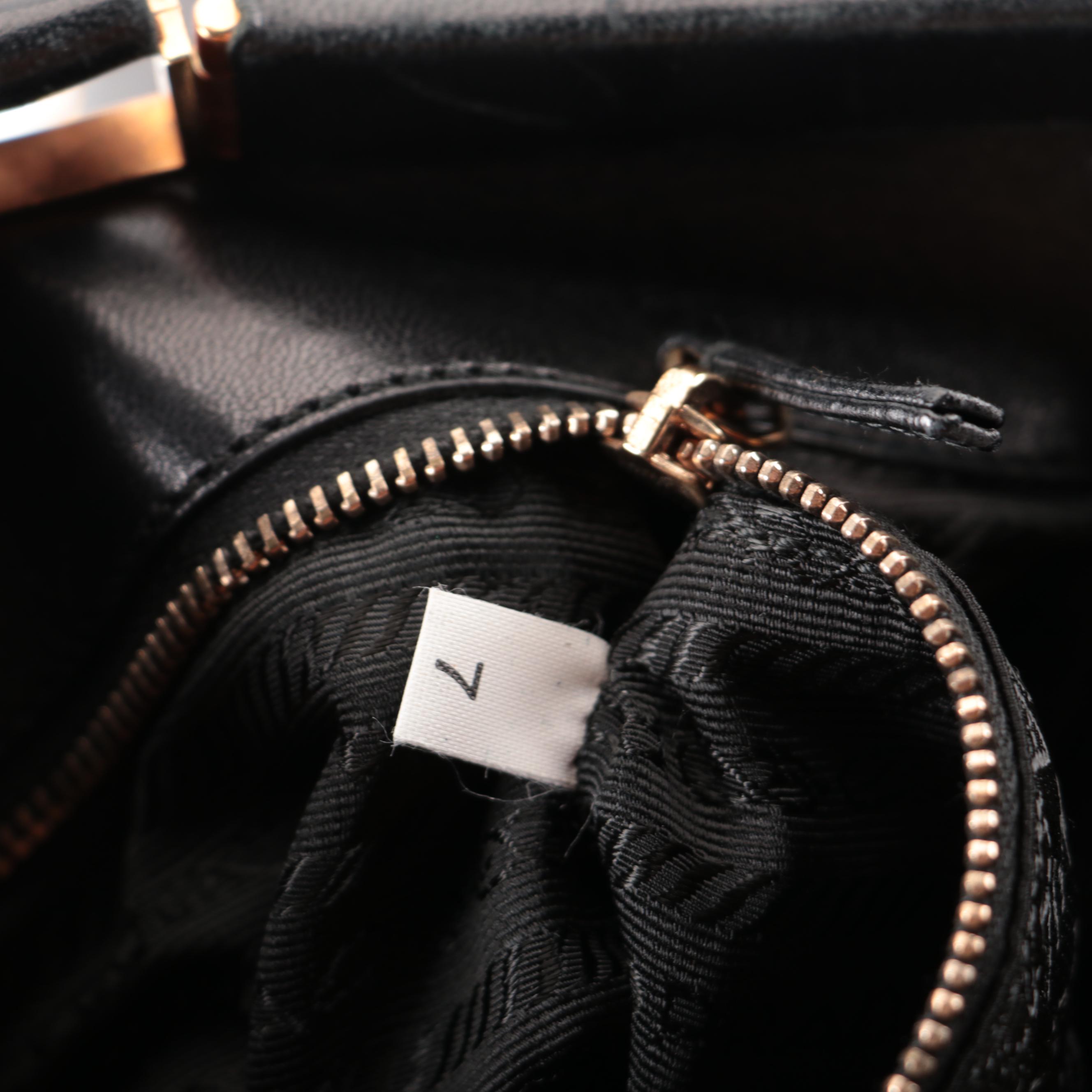 Prada Hinged Flat Shoulder Bag in Black Lambskin with Grommet Detail