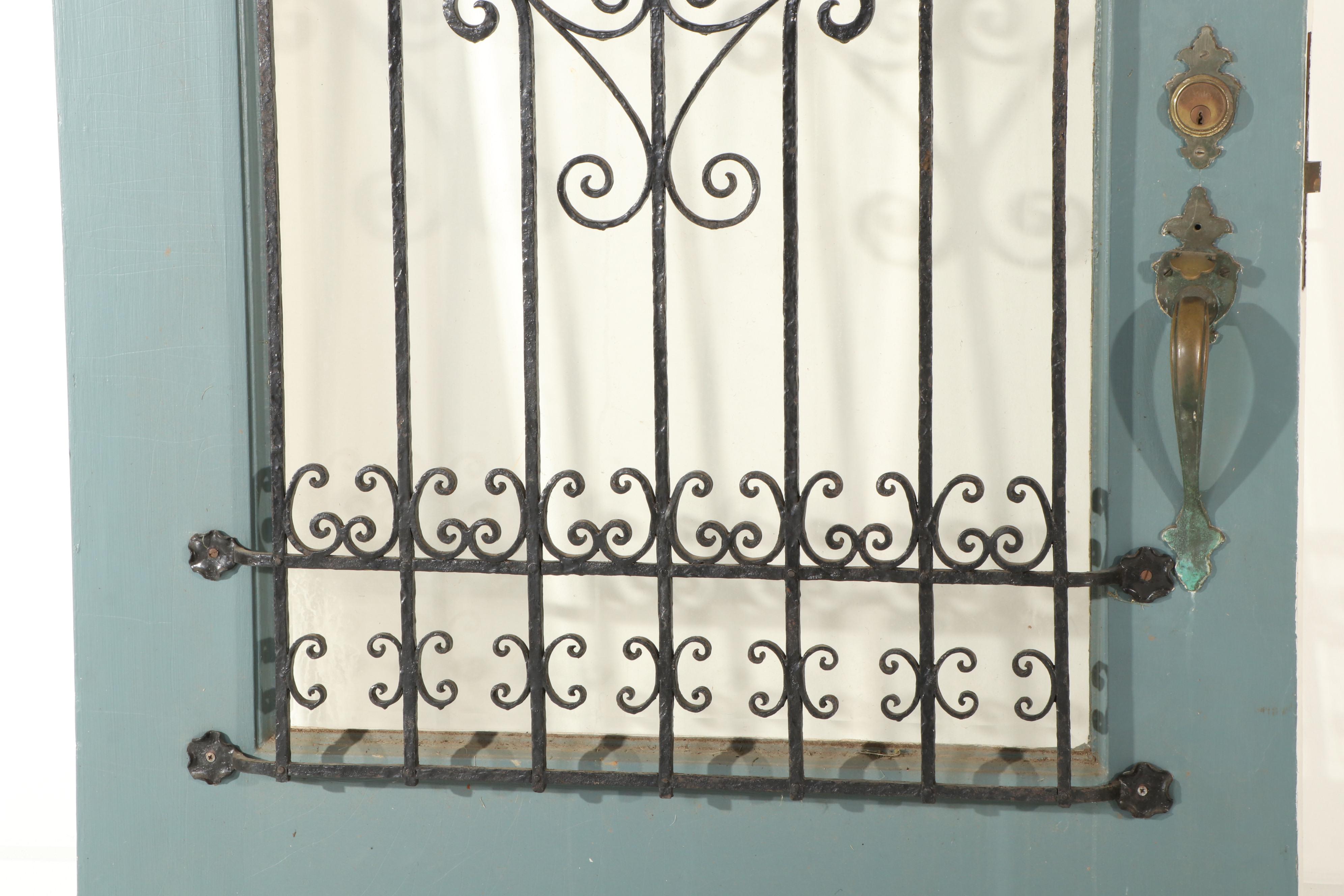 Gothic-Arched Exterior Door with Wrought Iron Grill and Beveled Glass