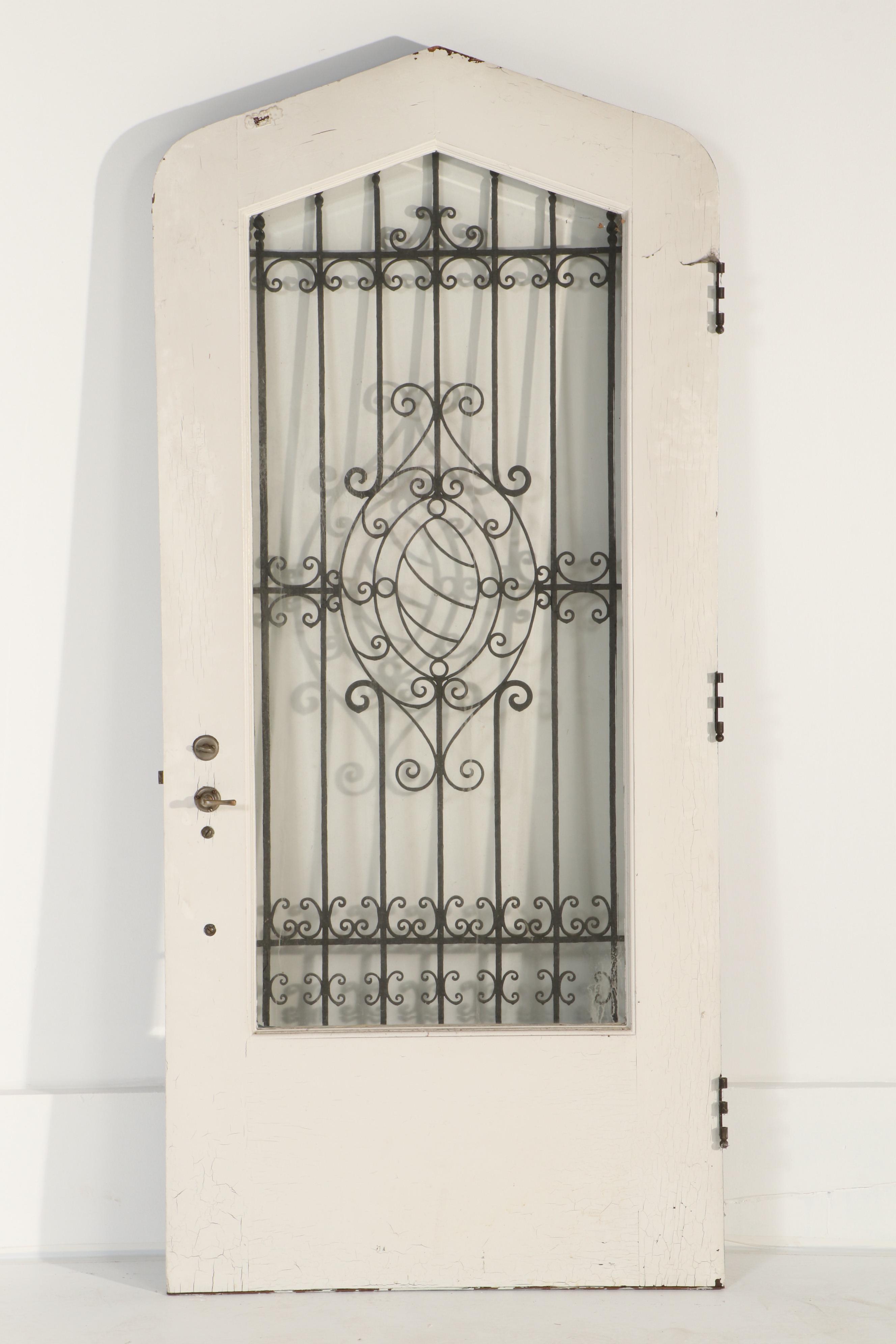 Gothic-Arched Exterior Door with Wrought Iron Grill and Beveled Glass