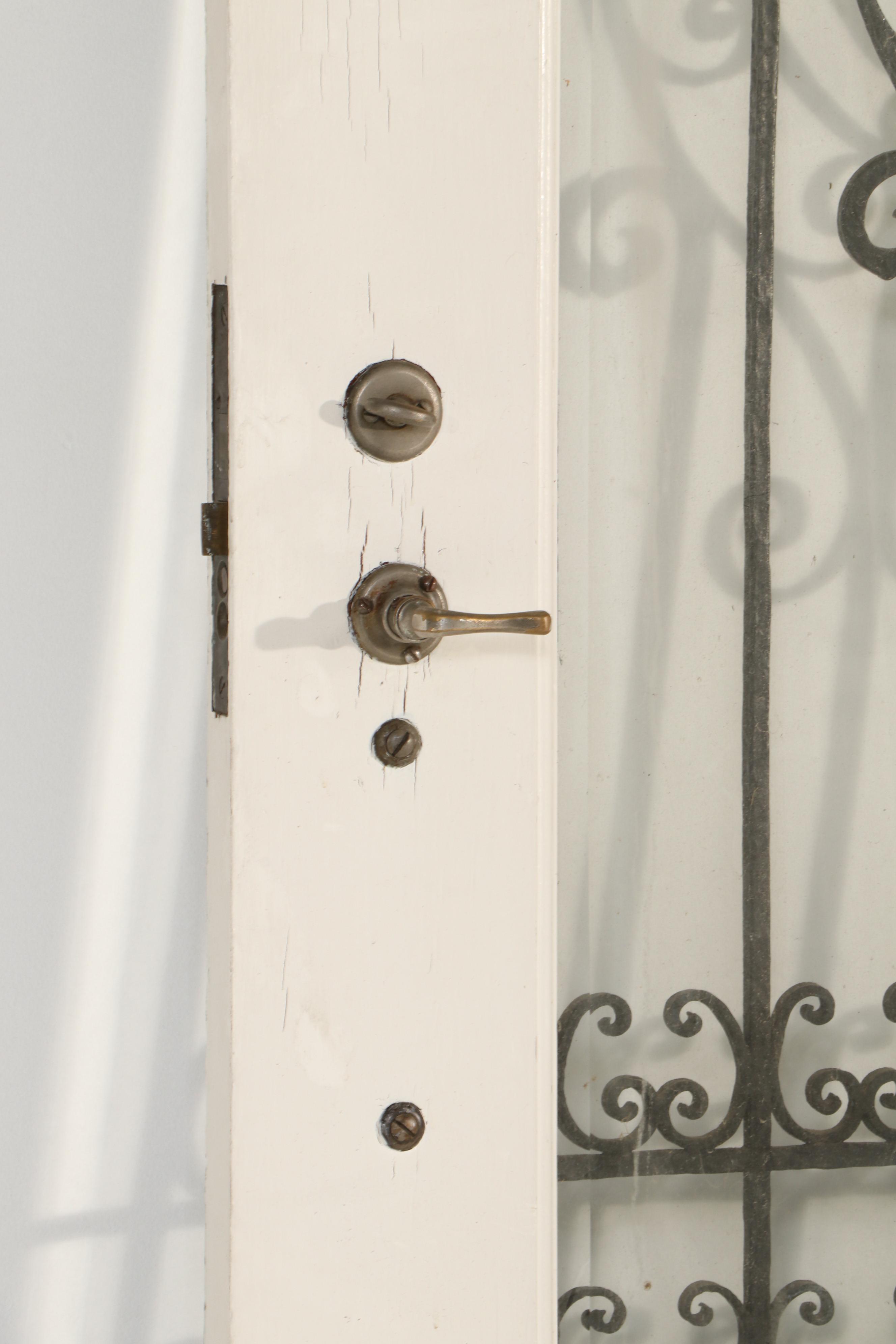 Gothic-Arched Exterior Door with Wrought Iron Grill and Beveled Glass