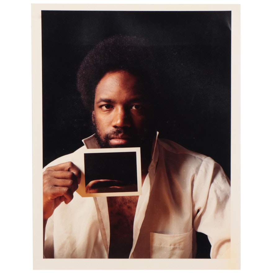 Chromogenic Photograph of Man Holding a Photograph, Circa 1985