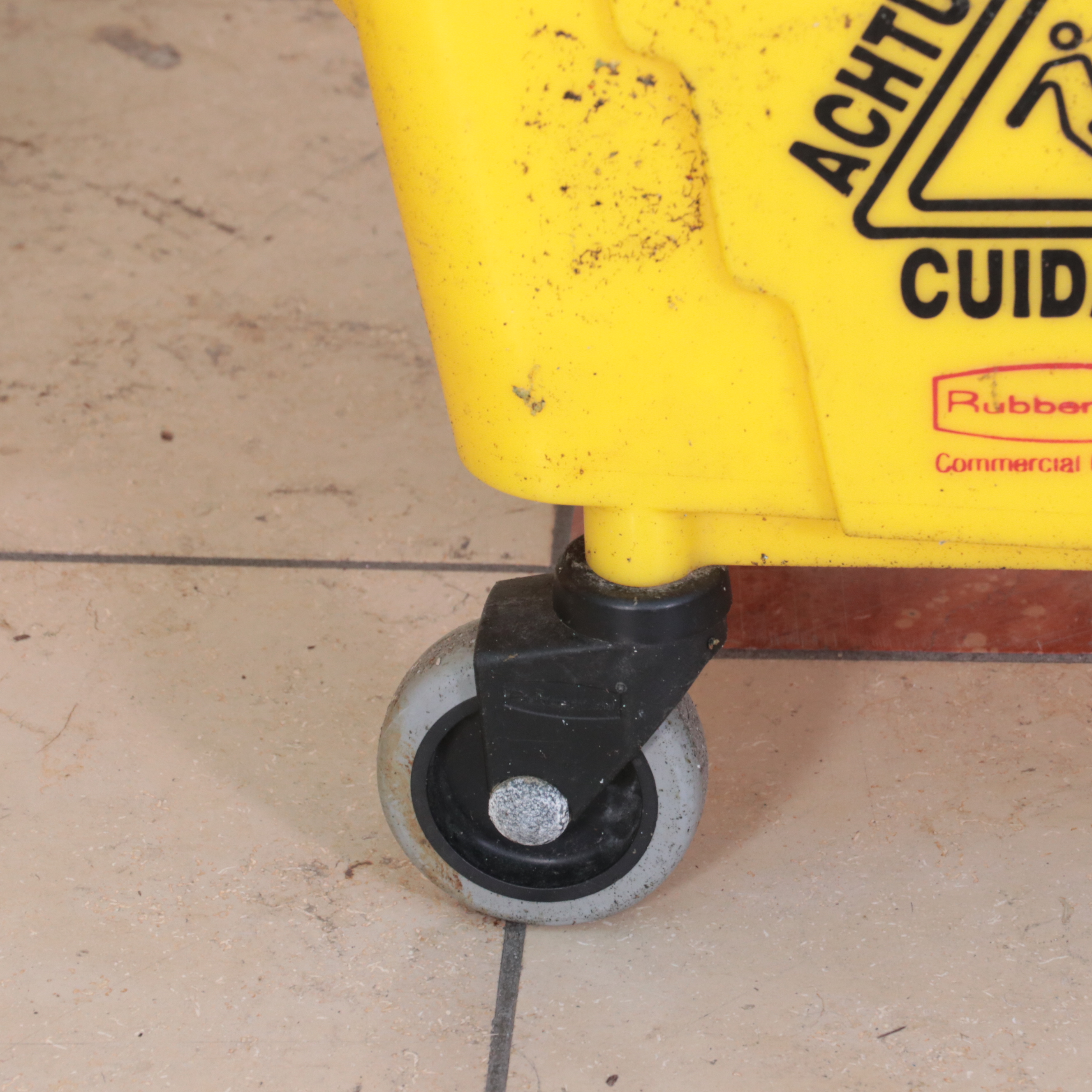 Six Rubbermaid Industrial Wheeled Mop Buckets With Three "Caution" Signs
