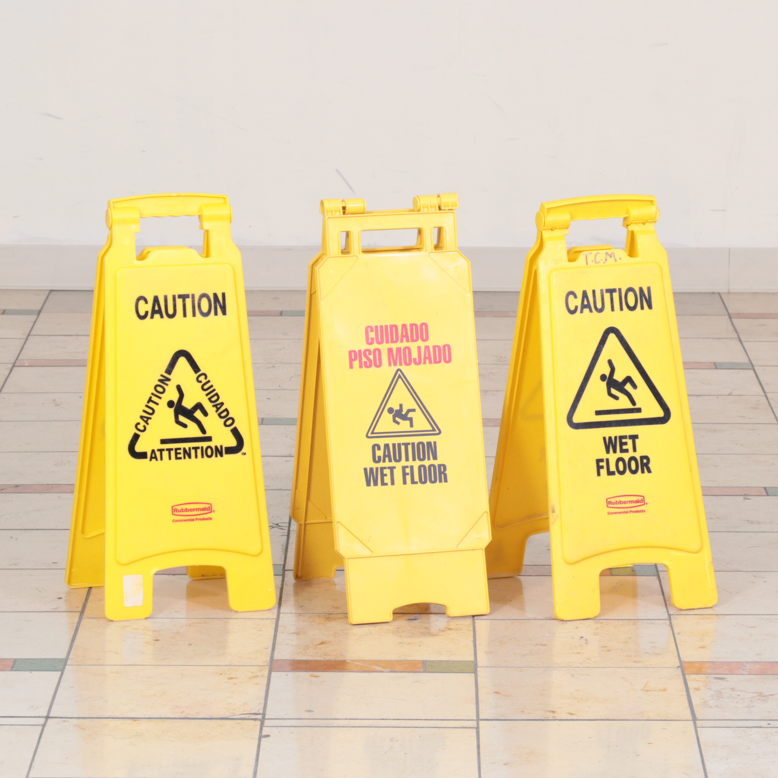 Six Rubbermaid Industrial Wheeled Mop Buckets With Three "Caution" Signs